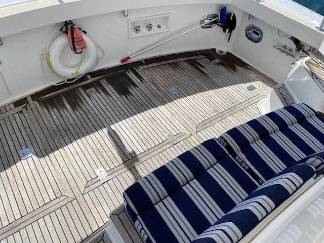 Teak deck of 2001 Grand Banks 49 Eastbay SX with striped seating and safety equipment.