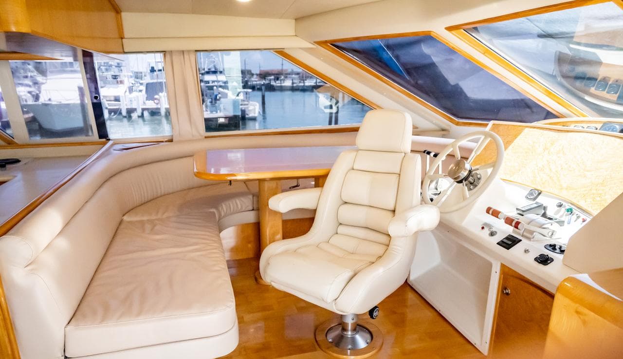 Luxurious interior of a 1999 Navigator 5800 yacht with leather seating and helm.