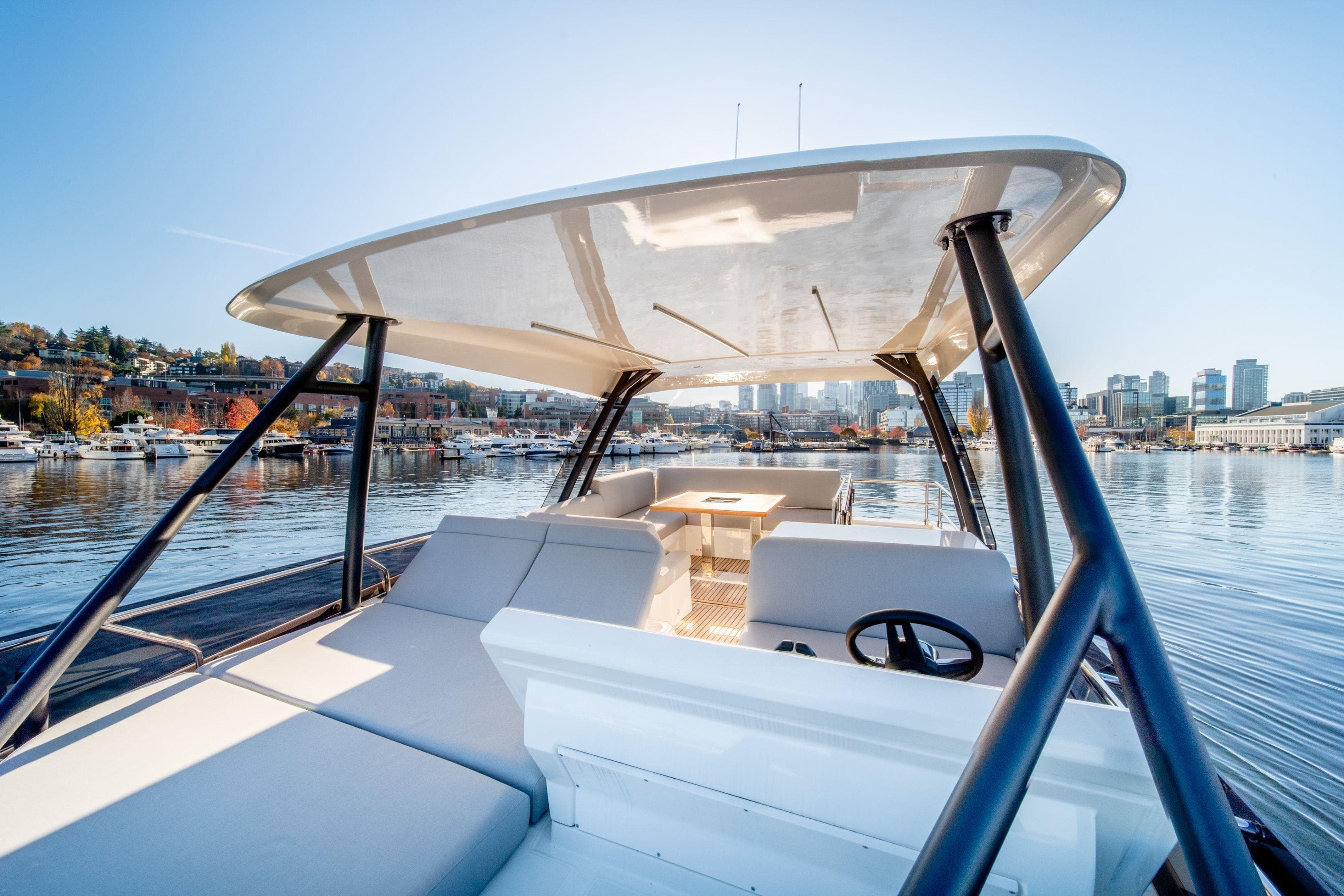 Luxurious 2026 Prestige 520 yacht on serene waterfront with city skyline backdrop.
