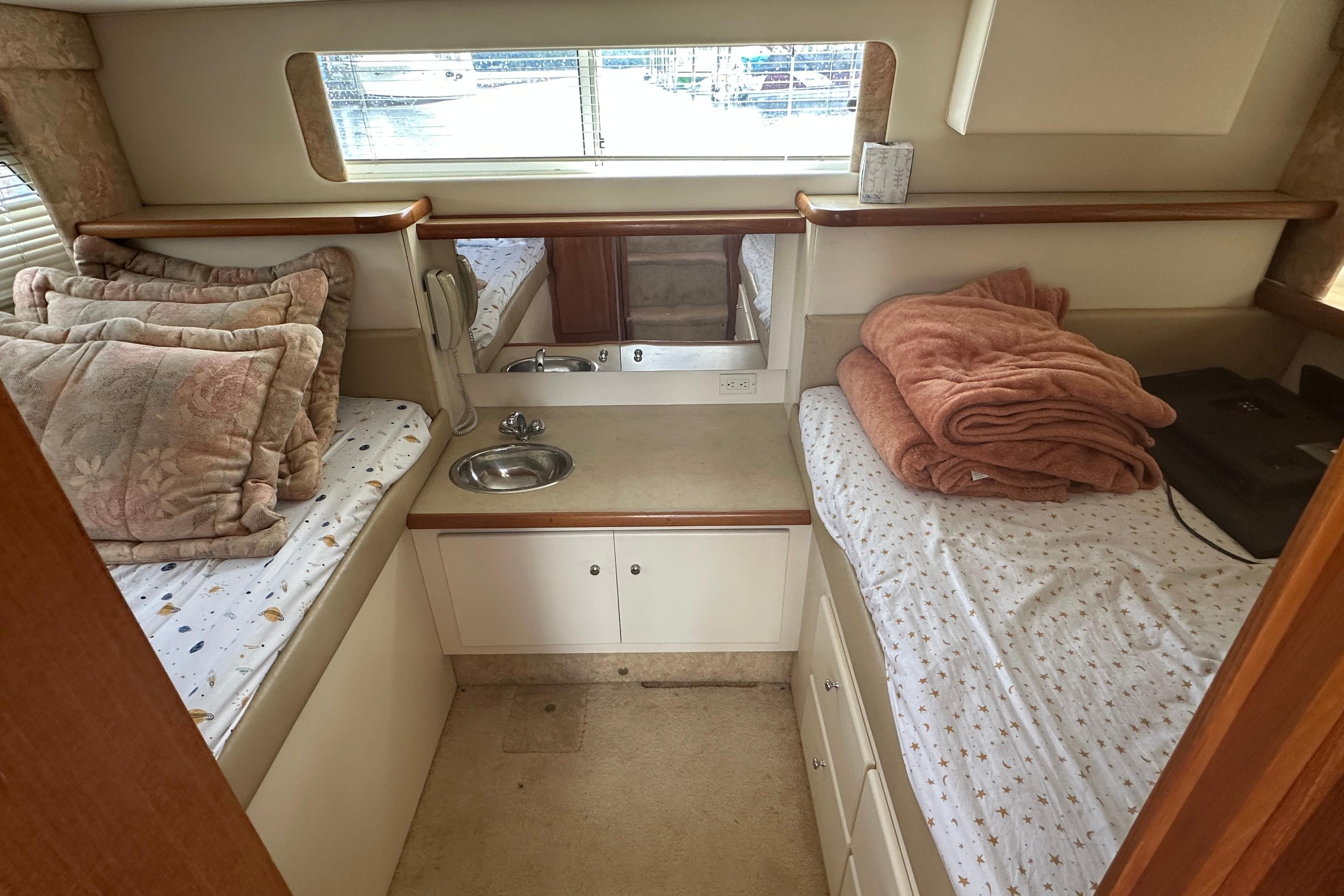 1997 Carver 325 Motor Yacht cabin with twin beds, pillows, and a small sink.