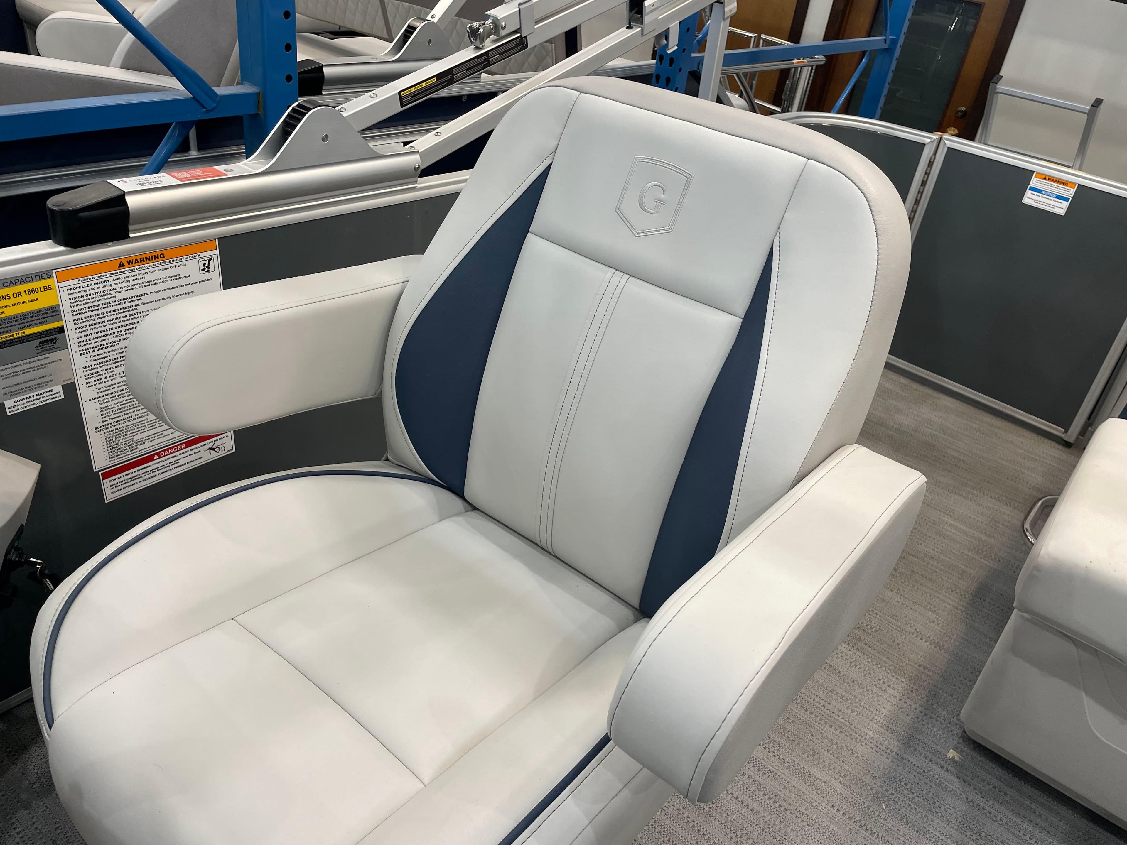 Luxurious seating on 2025 Godfrey Sweetwater 2086 C pontoon boat, featuring white and blue upholstery.