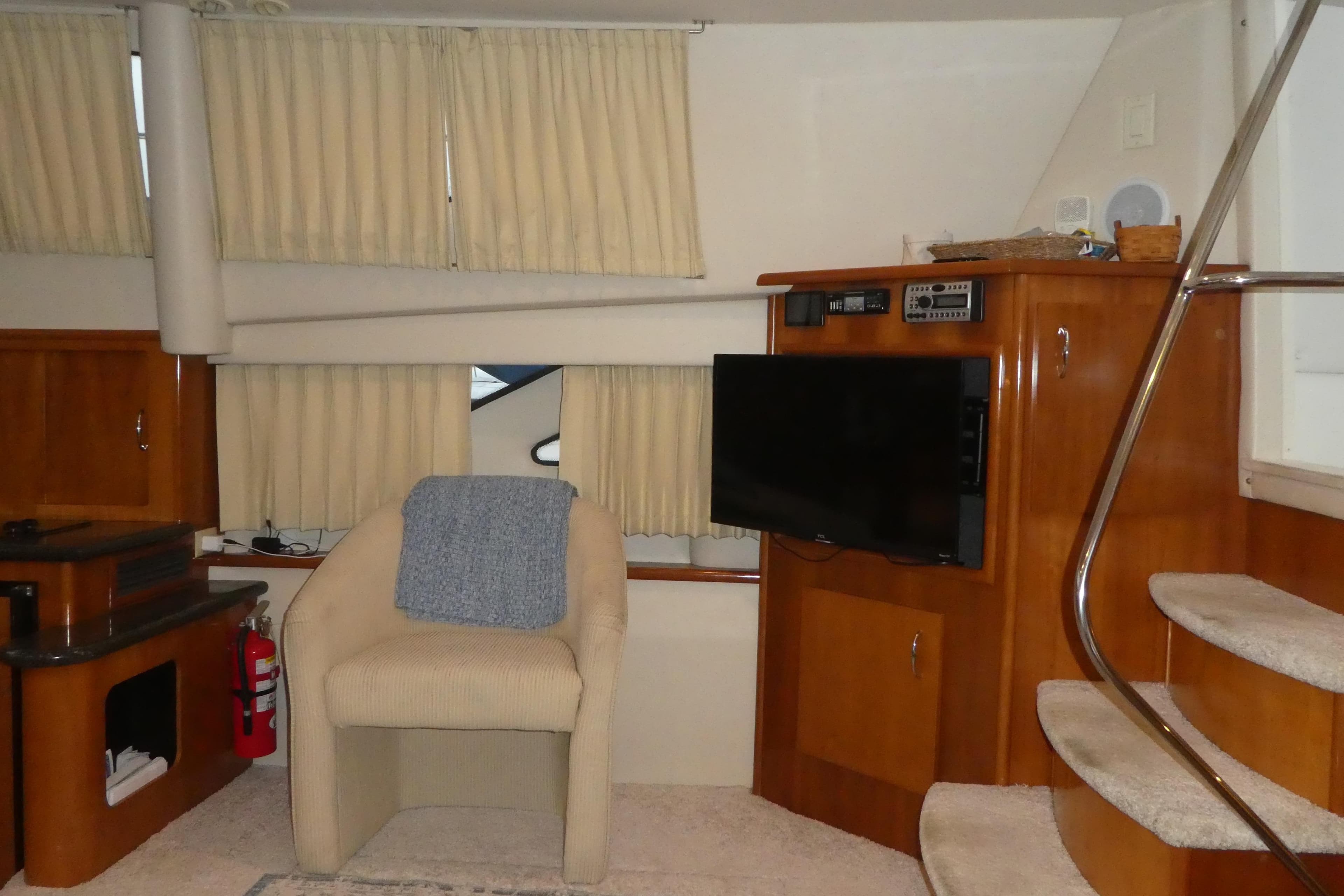 Interior of 2006 Carver 366 Motor Yacht with chair, TV, and stairs.