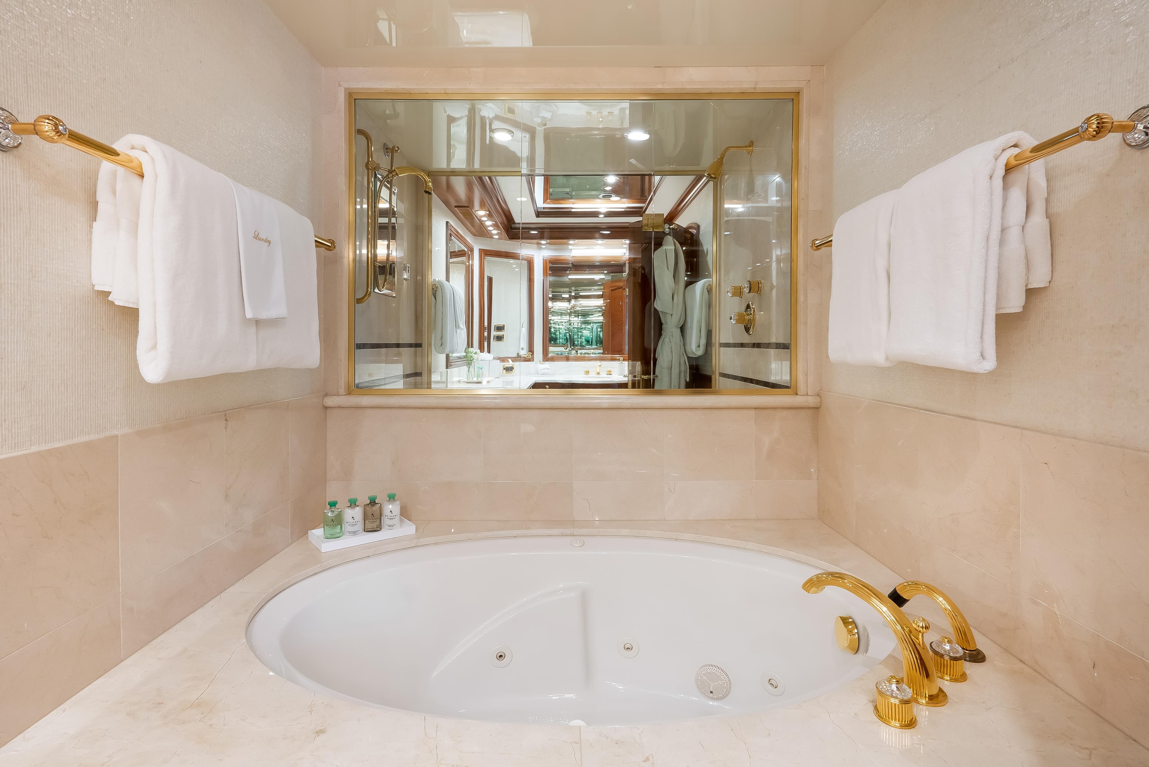 Luxurious yacht bathroom with jacuzzi tub, gold fixtures, and plush towels. Richmond Yachts 2004.