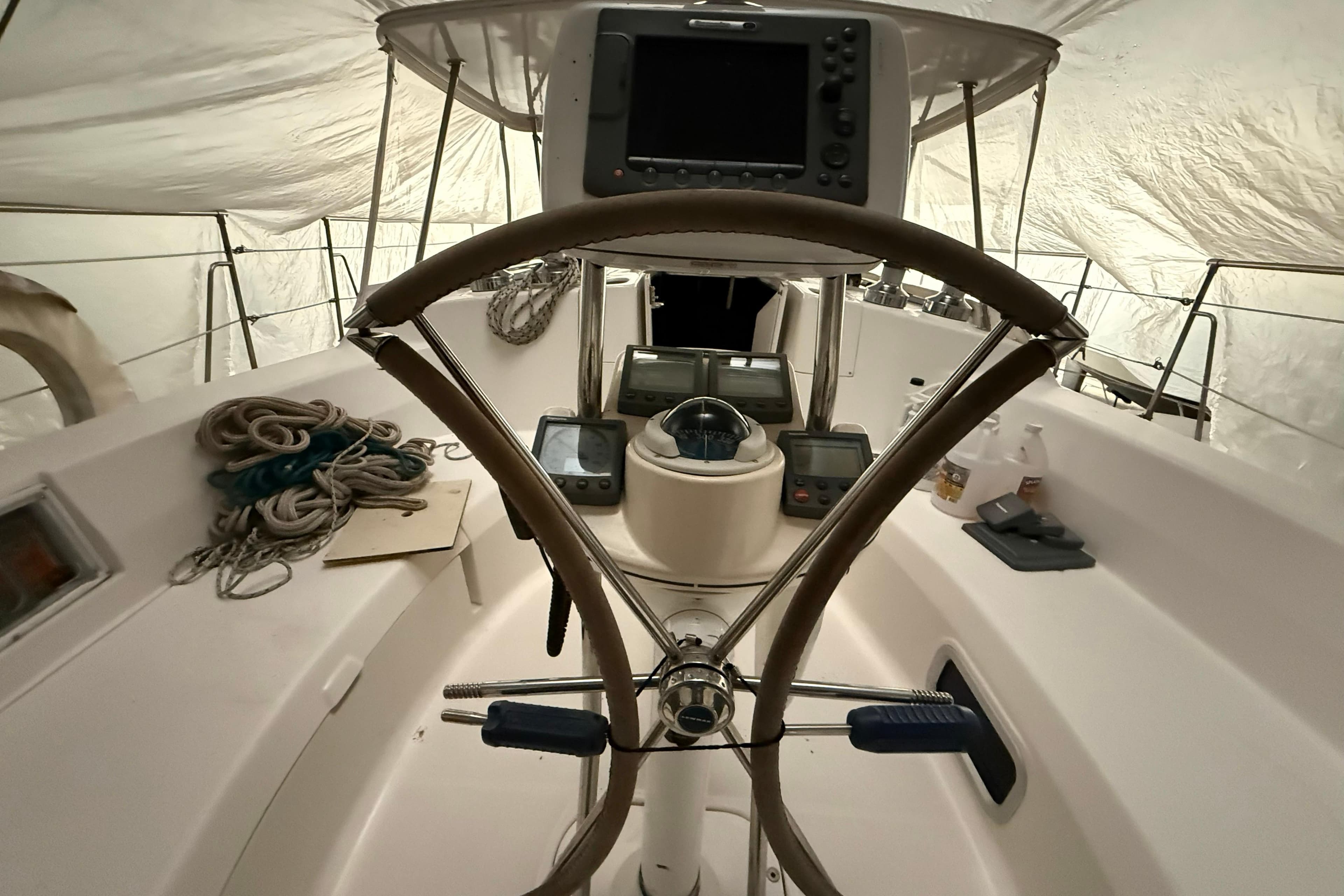 Interior view of 2005 Hunter 46LE sailboat cockpit with steering wheel and navigation equipment.