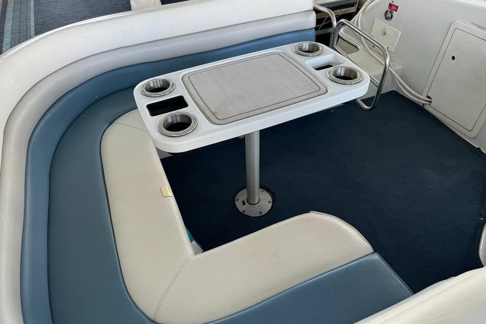 1994 Chris-Craft 322 Crowne boat interior with cushioned seating and table with cup holders.