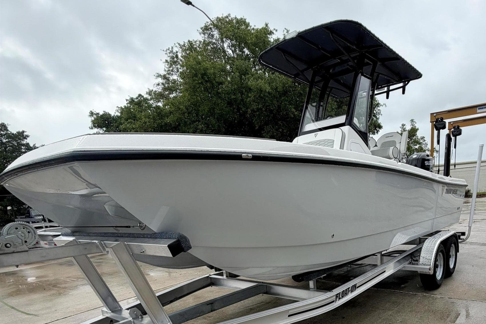 2026 Twin Vee 22 BayCat boat on trailer, featuring sleek design and T-top canopy.