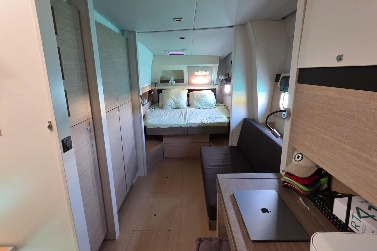 Interior of a 2016 Bali 4.5 yacht cabin with bed, sofa, and desk.