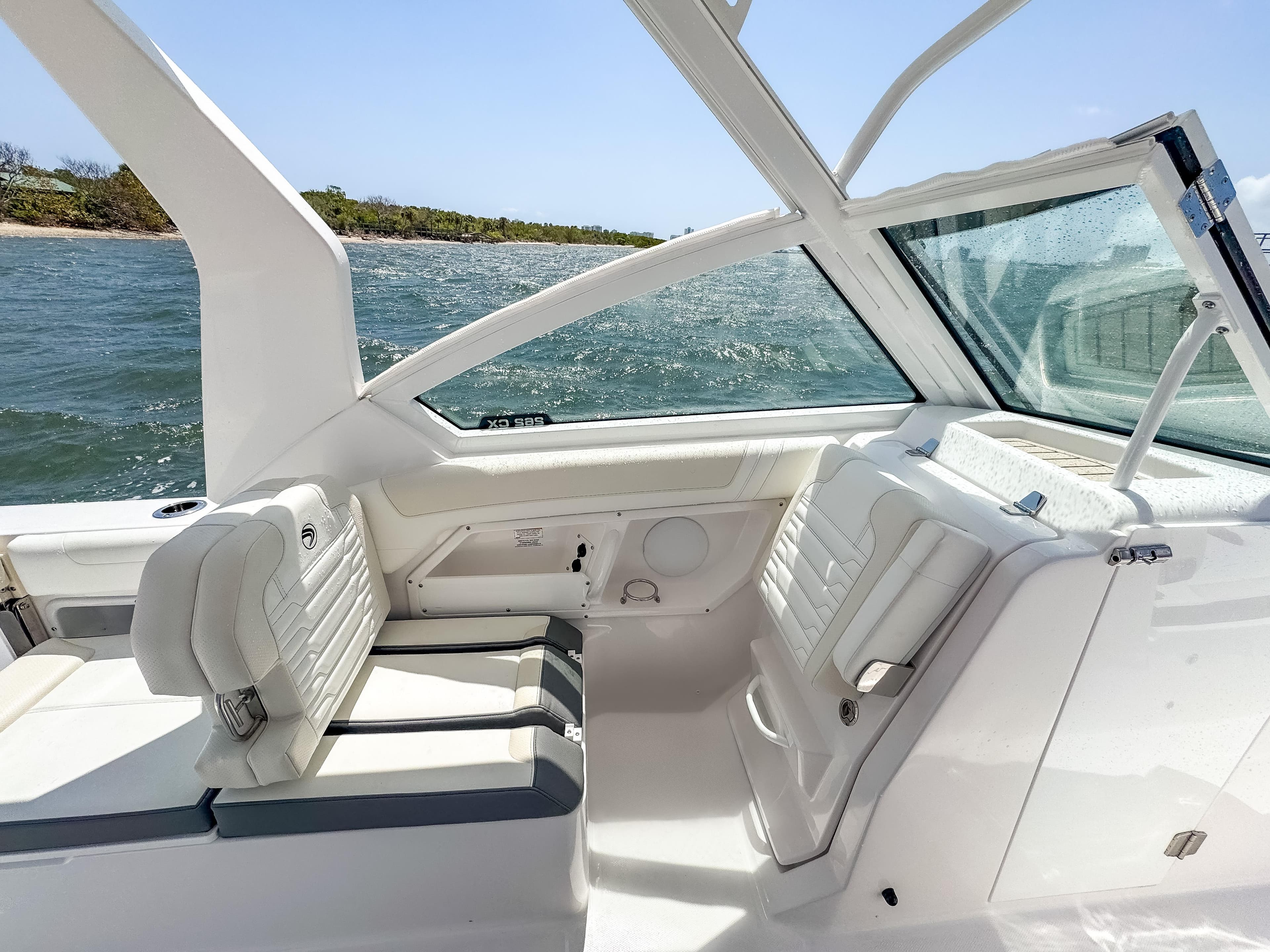 2025 Edgewater 262 CX boat interior with white seating, ocean view, and sleek design.