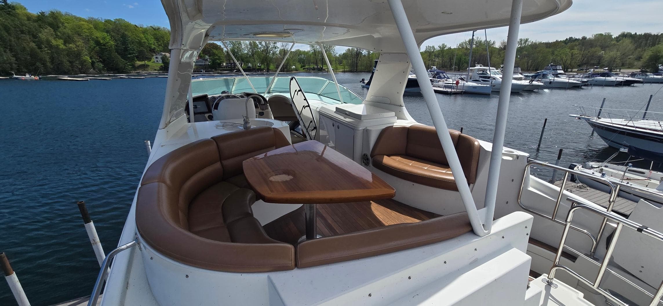 2005 Carver 560 Voyager yacht with spacious seating and table on deck, docked at marina.