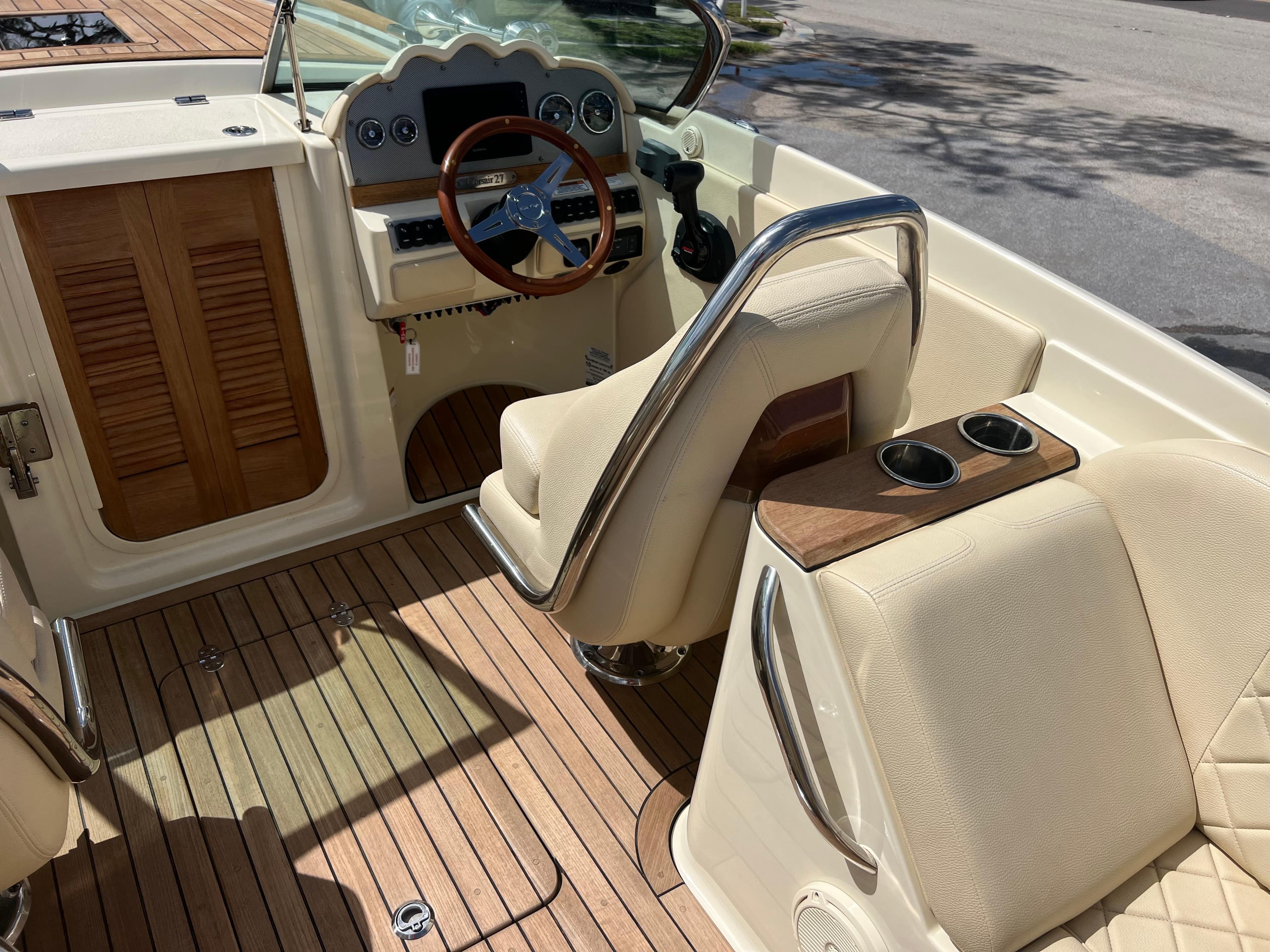 2019 Chris-Craft Corsair 27 interior with wooden accents and beige seating.