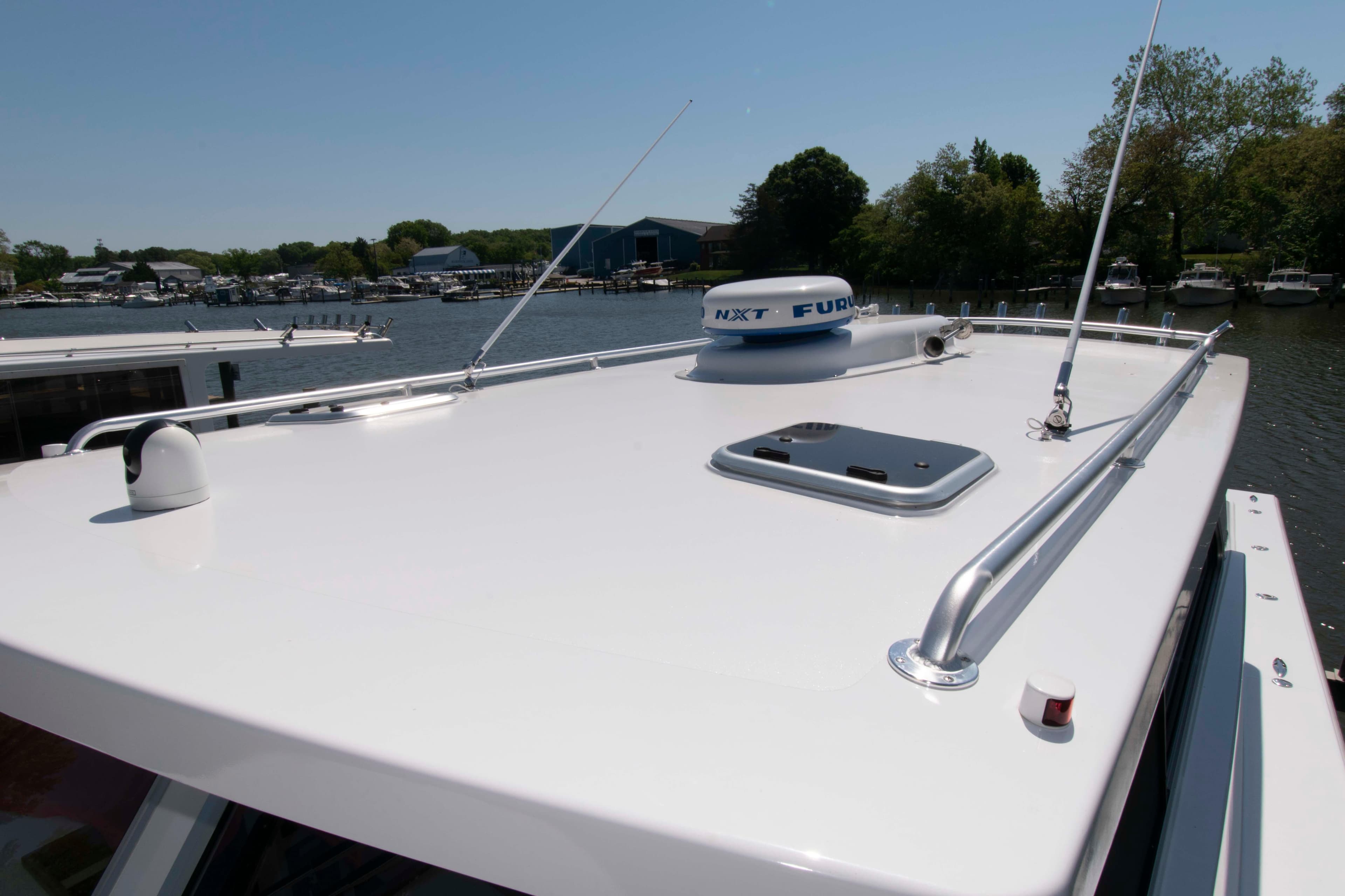 2024 Composite Yacht CY 42 rooftop with radar, docked in a serene marina setting.