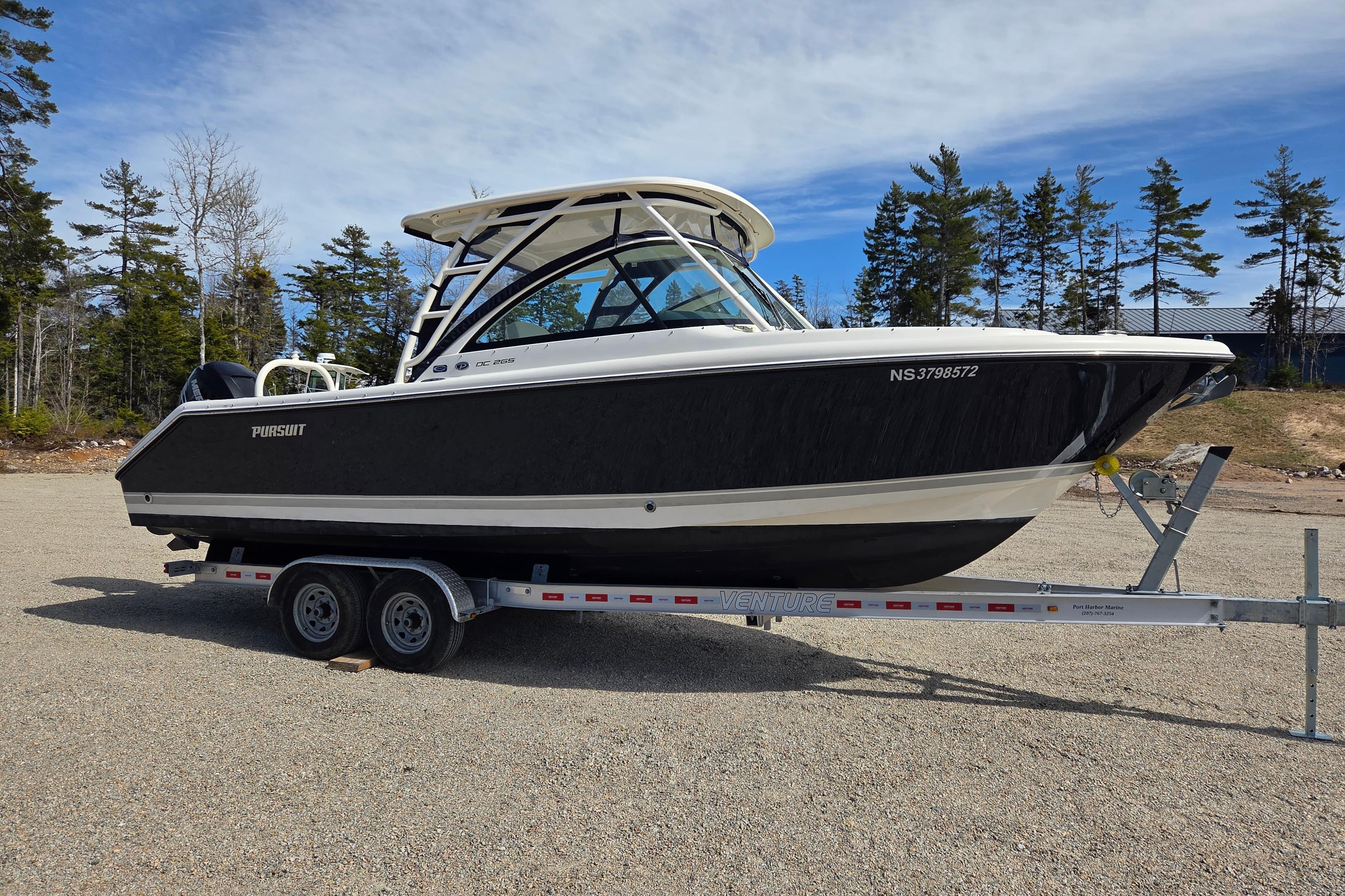 2011 Pursuit DC 265 Dual Console boat on trailer, parked outdoors.