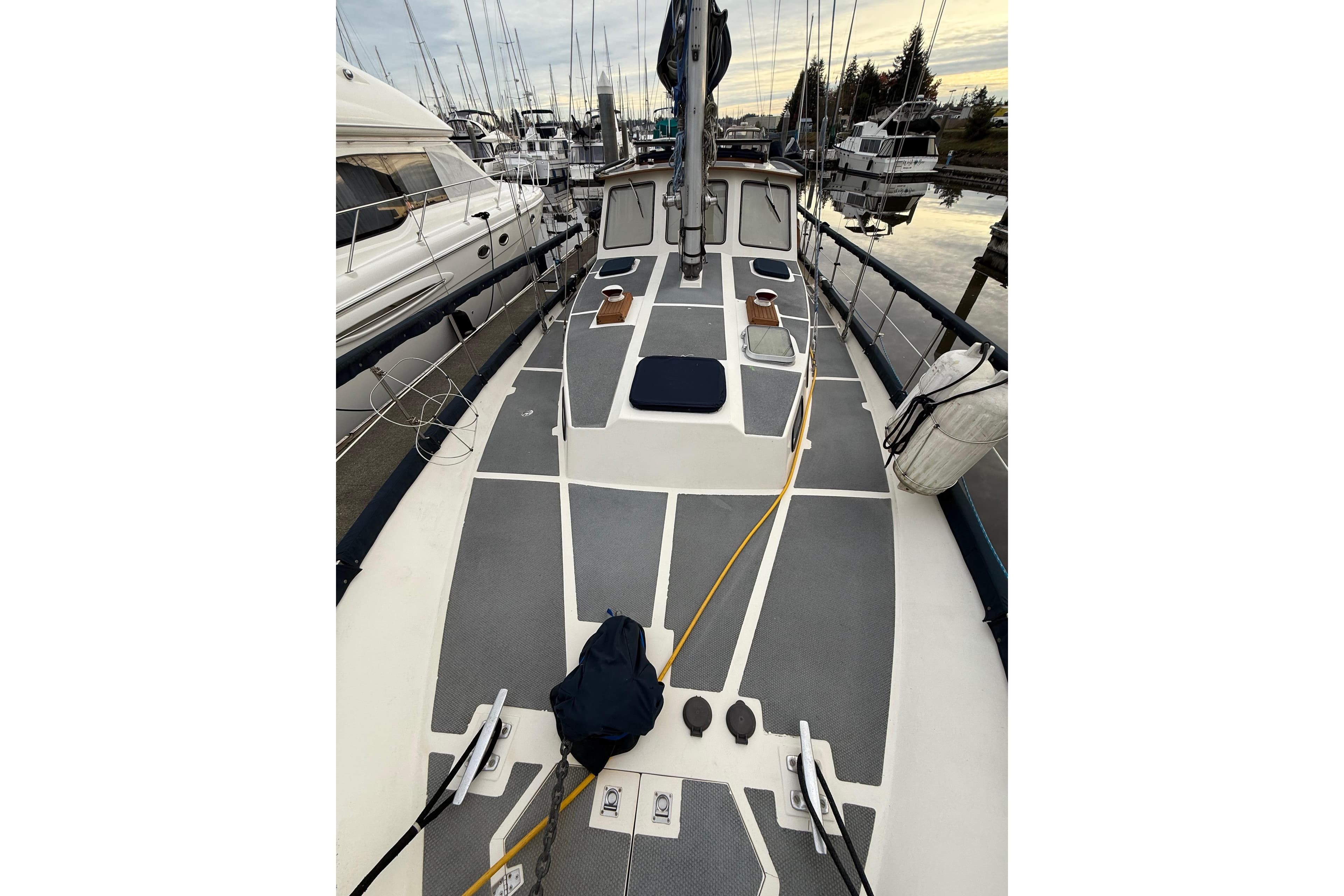 1980 Nauticat Pilothouse sailboat deck view at marina, surrounded by other boats.