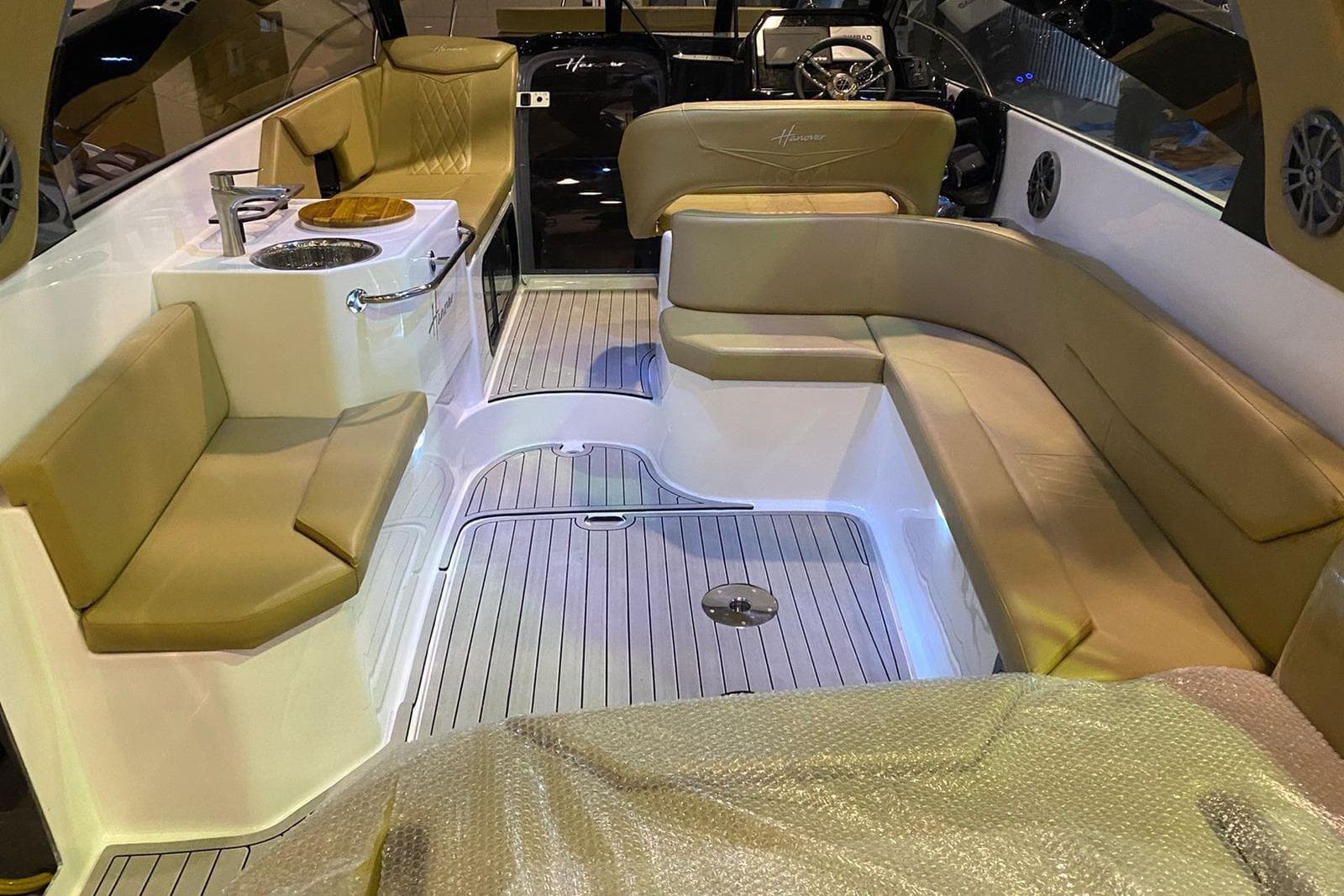 2024 Hanover 305 boat interior with beige seating and modern amenities.