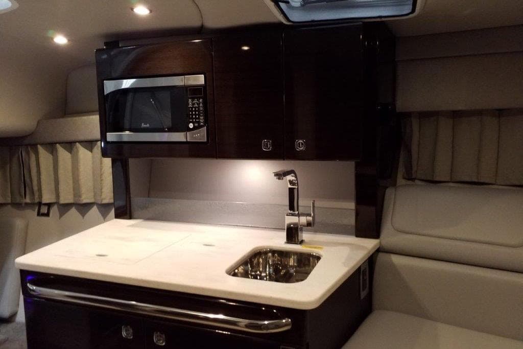 2021 Formula 350 Sun Sport interior with kitchenette, featuring a microwave and sink.