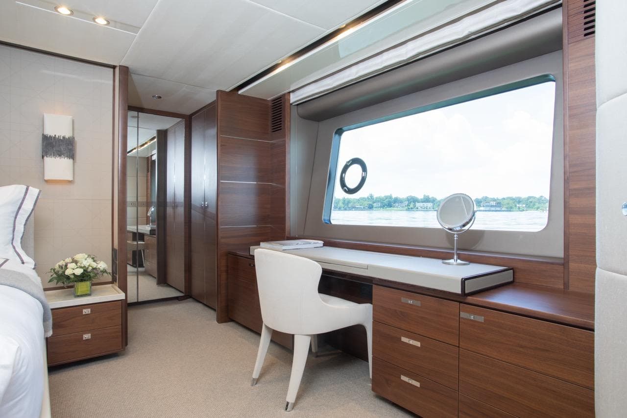 Luxurious interior of 2019 Princess Y88 Motor Yacht with elegant wood furnishings and large window view.