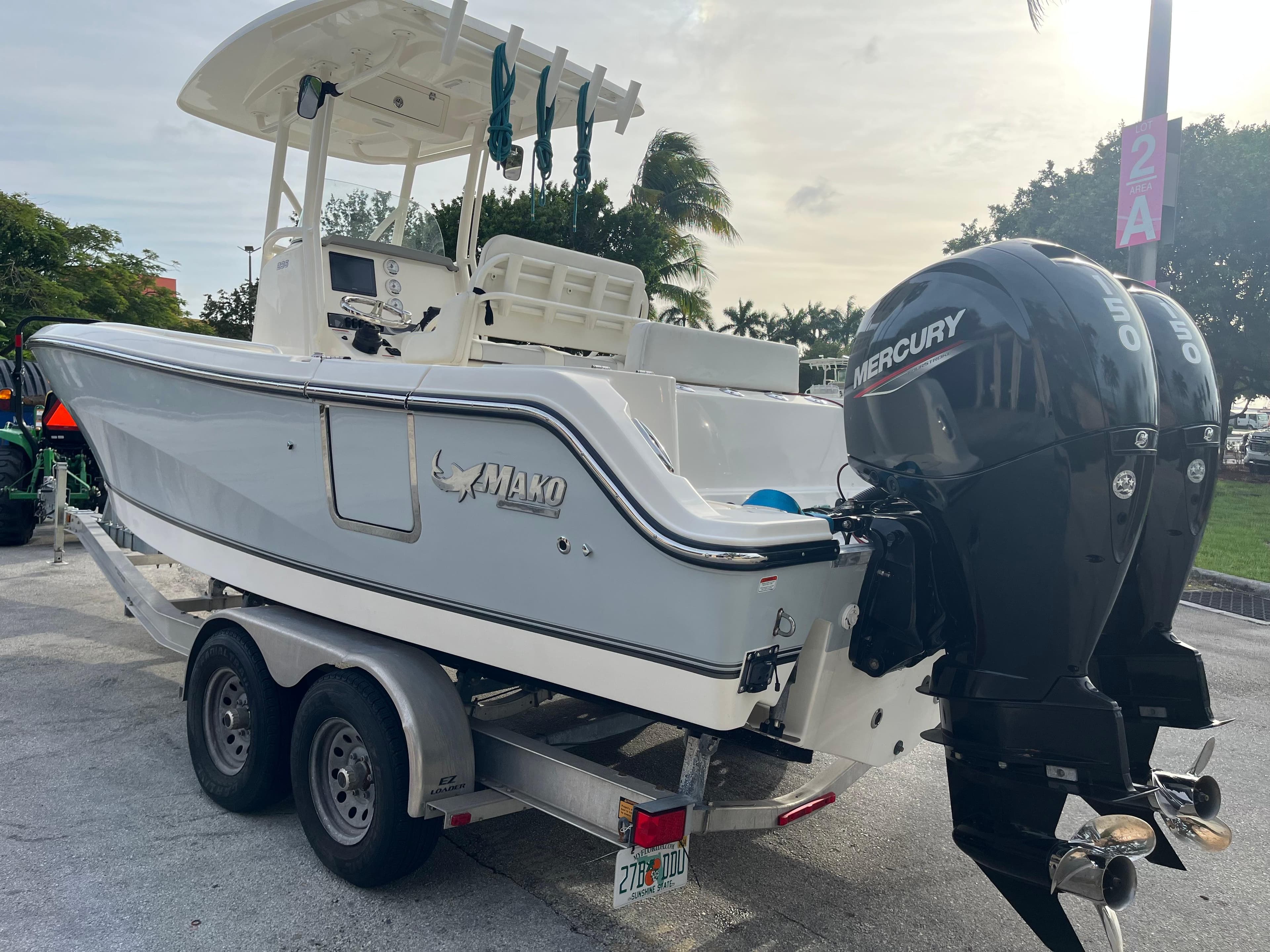 2020 Mako 236 CC boat on trailer with dual Mercury engines, parked outdoors.