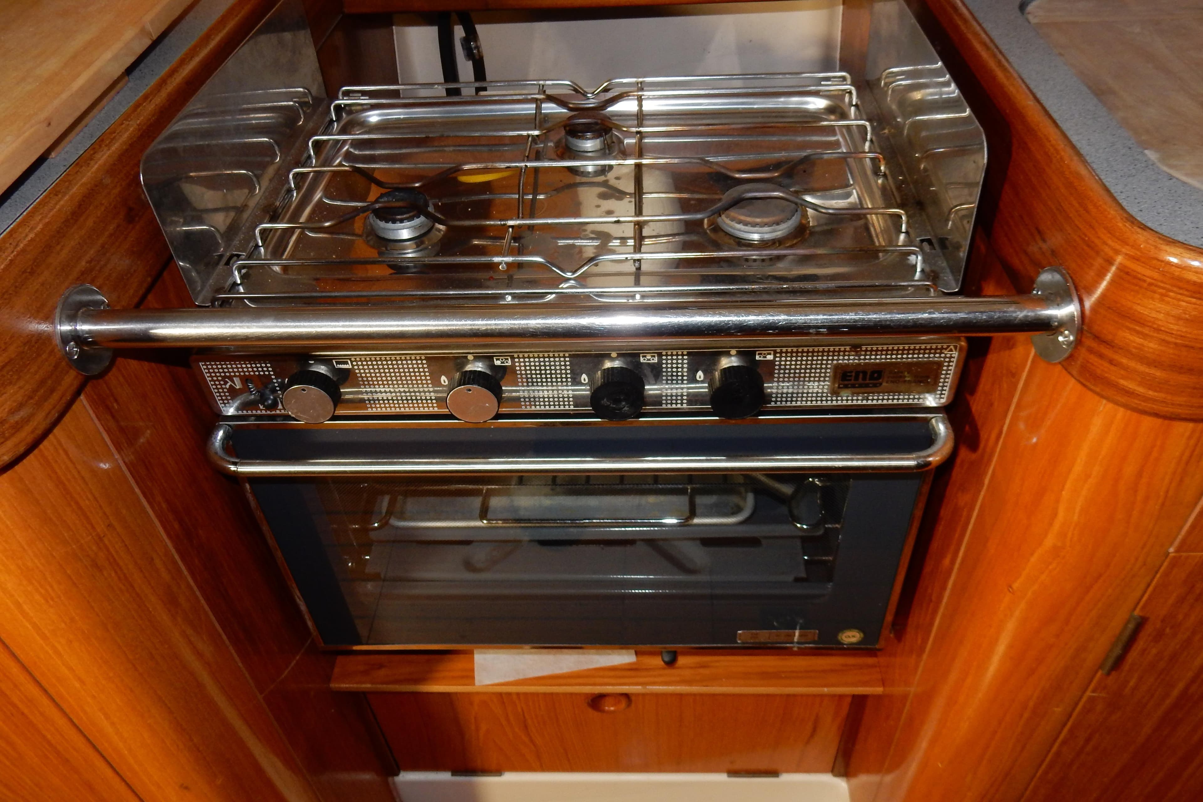 Stove and oven in 1991 Beneteau Oceanis 370 yacht kitchen, featuring wooden cabinetry.