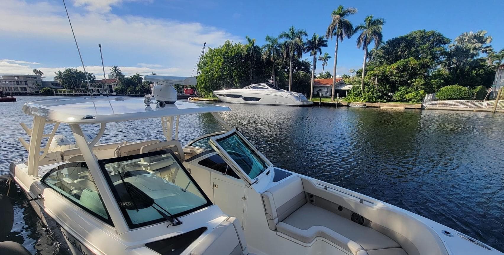 Boston Whaler 320 Vantage 2021 on calm water with palm trees in the background.