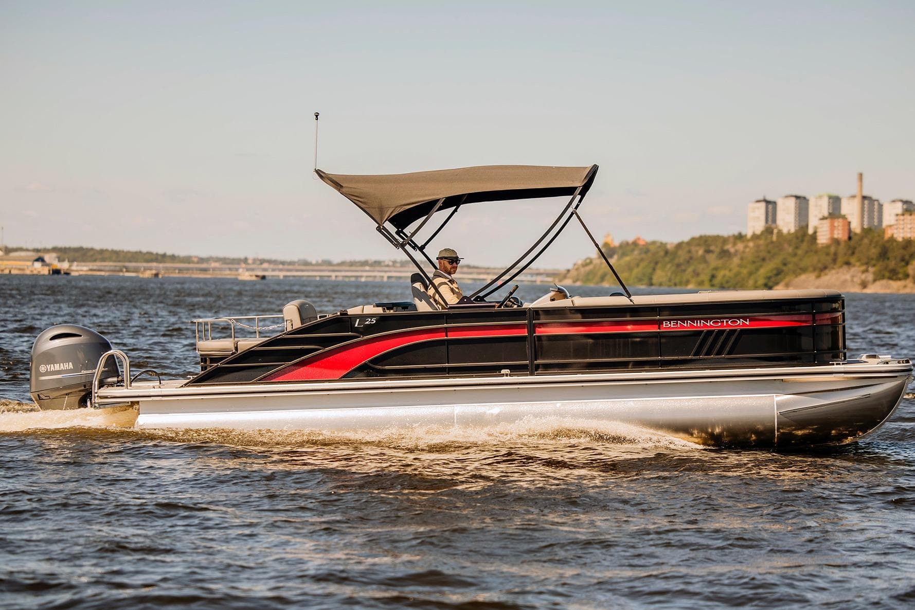 2024 Bennington L 25 Swingback Bowrider cruising on a scenic waterway.
