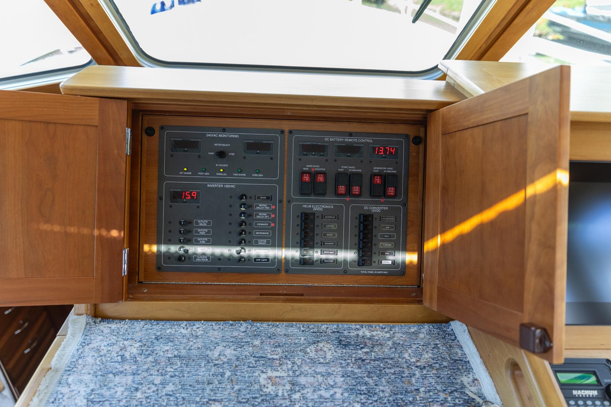 Electrical control panel on a 2009 Sabre 52 Express yacht, with wooden cabinet doors open.