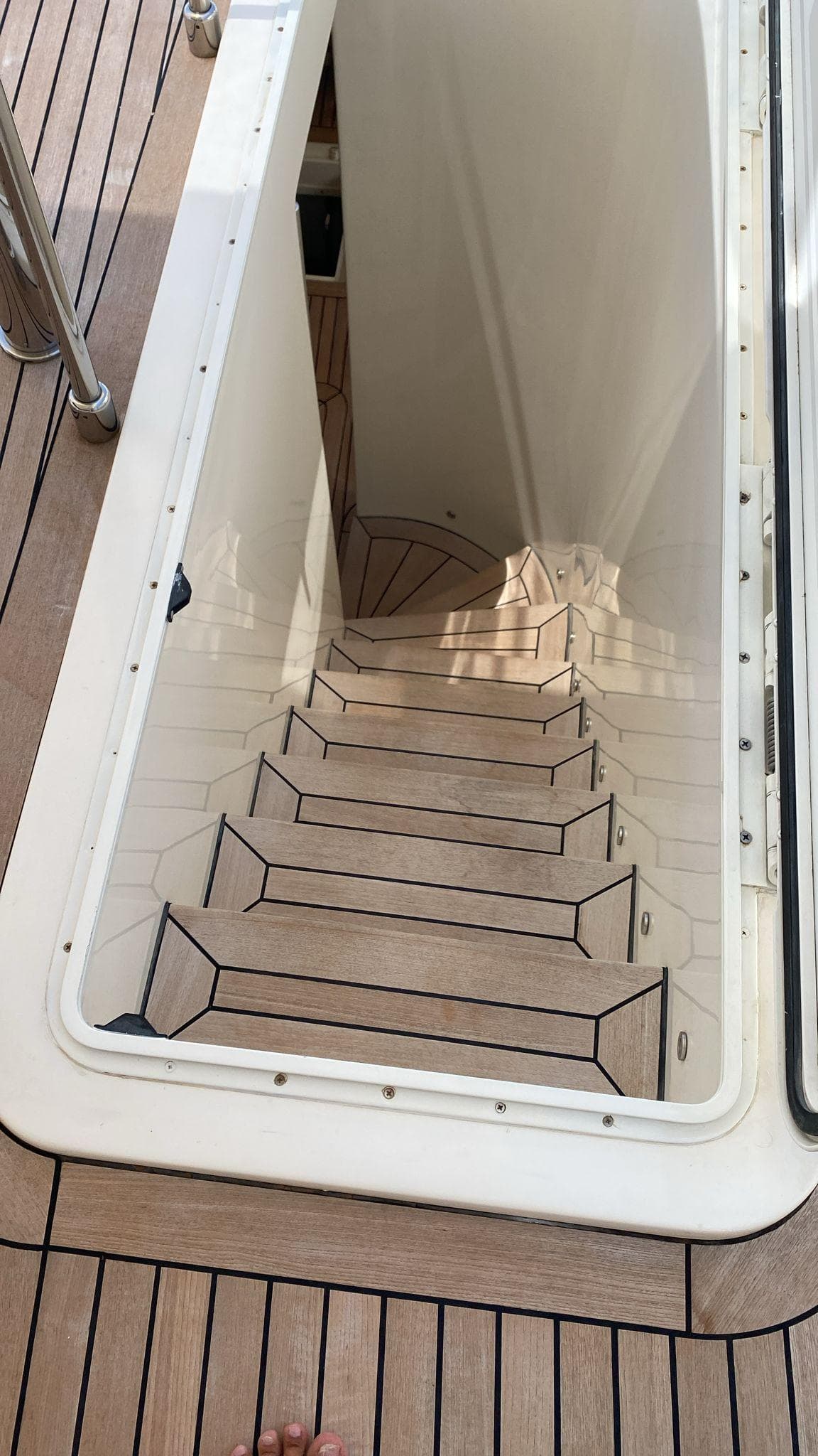 Staircase on Custom Line Navetta 33 yacht, 2010 model, with wooden steps and sleek design.
