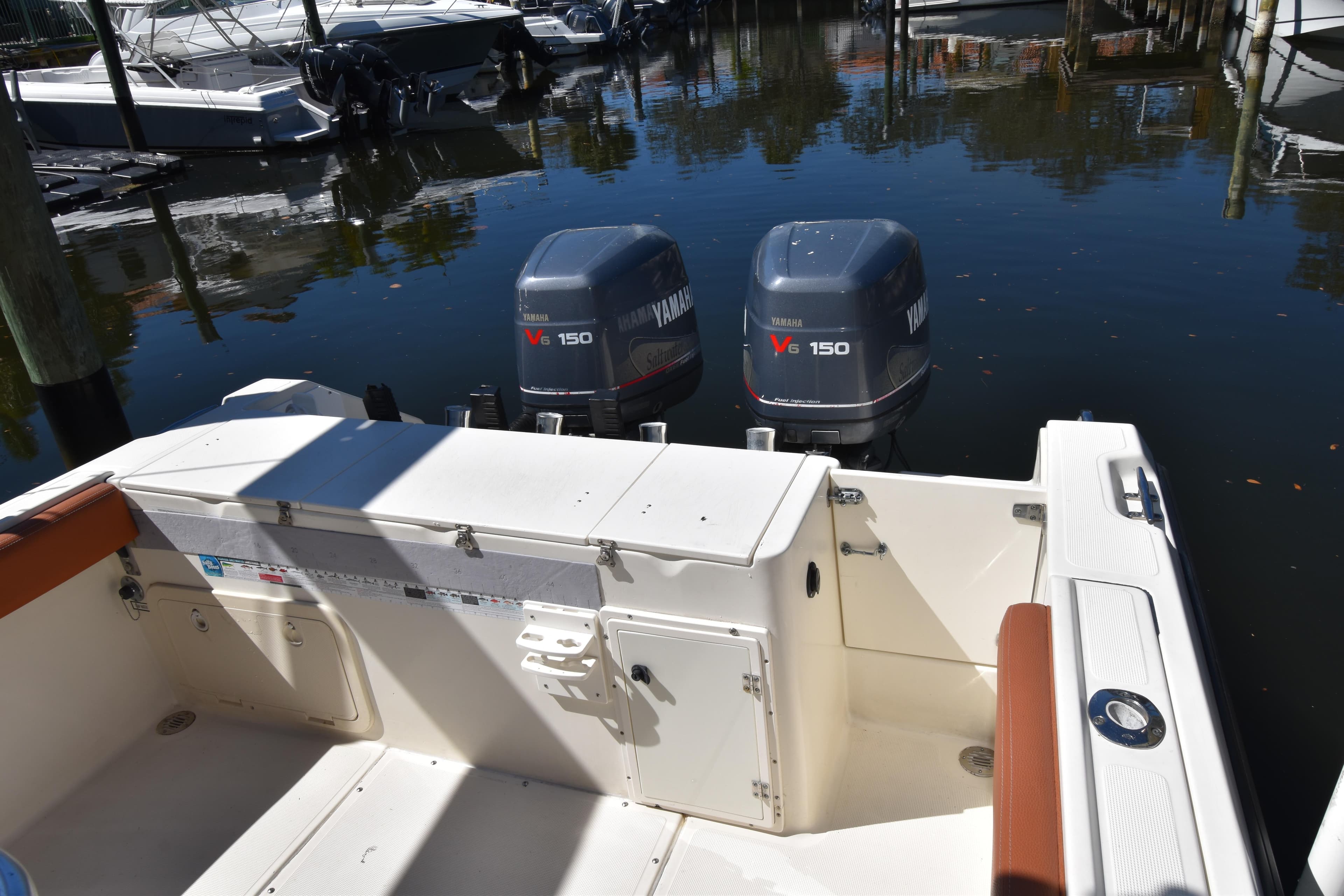 2001 Pursuit 2470 Center Console boat with twin Yamaha V6 150 engines docked.