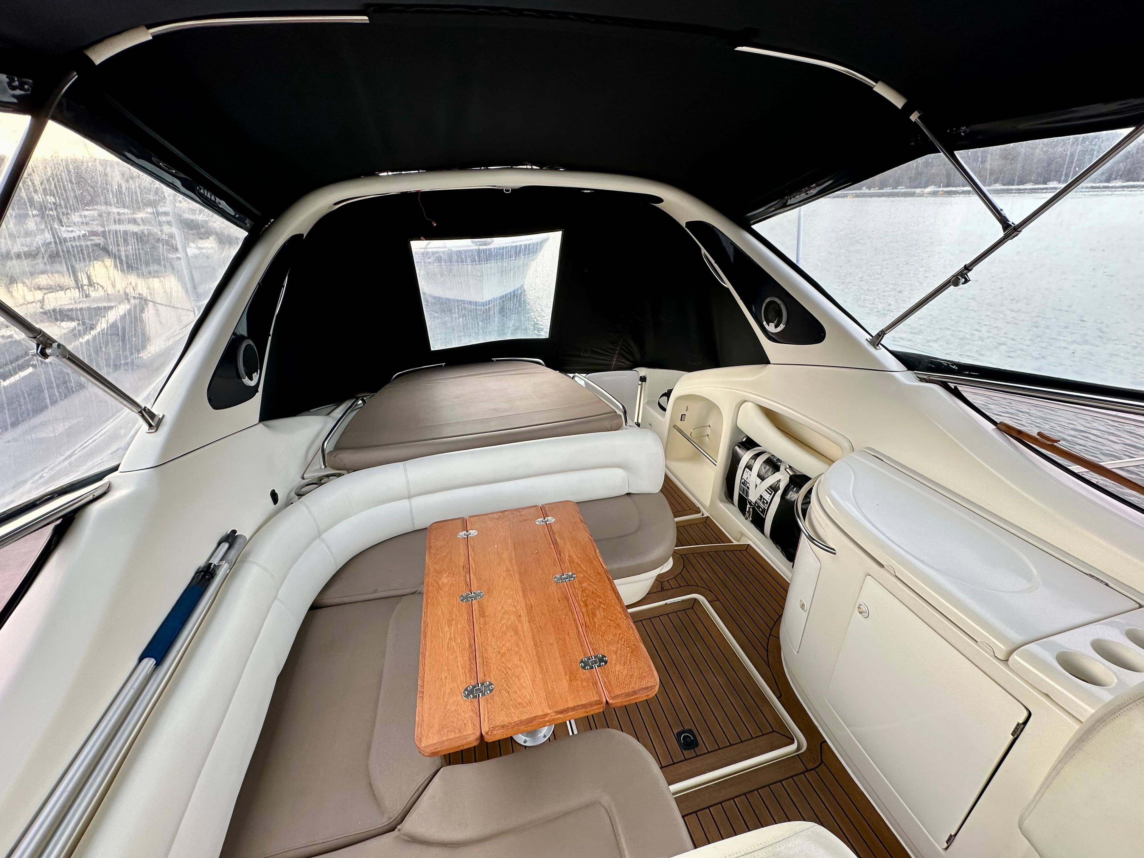1999 Cranchi Endurance 39 yacht interior with seating and wooden table, docked by the water.