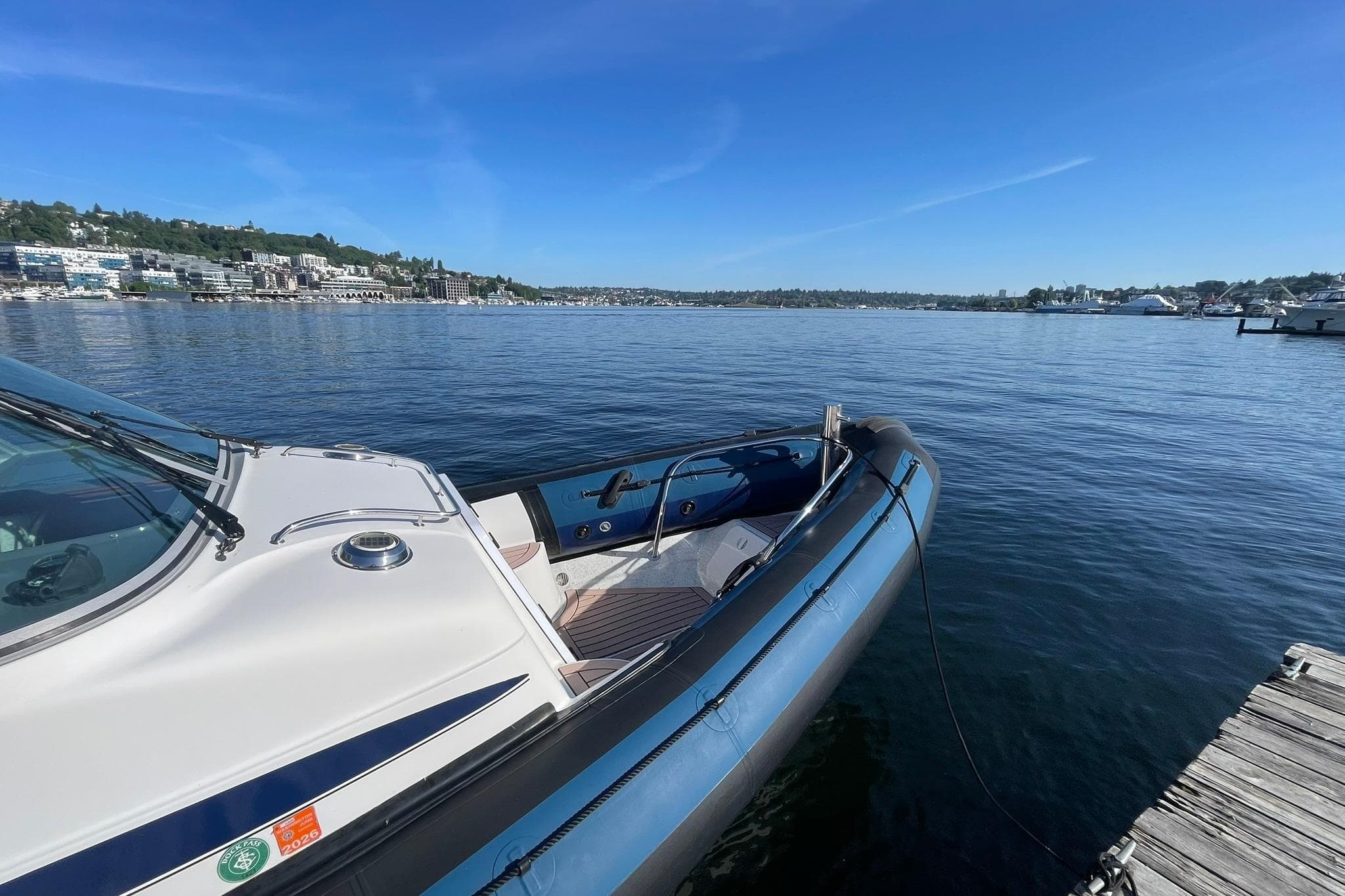 2004 Protector Targa 28 boat docked on a serene lake under a clear blue sky.