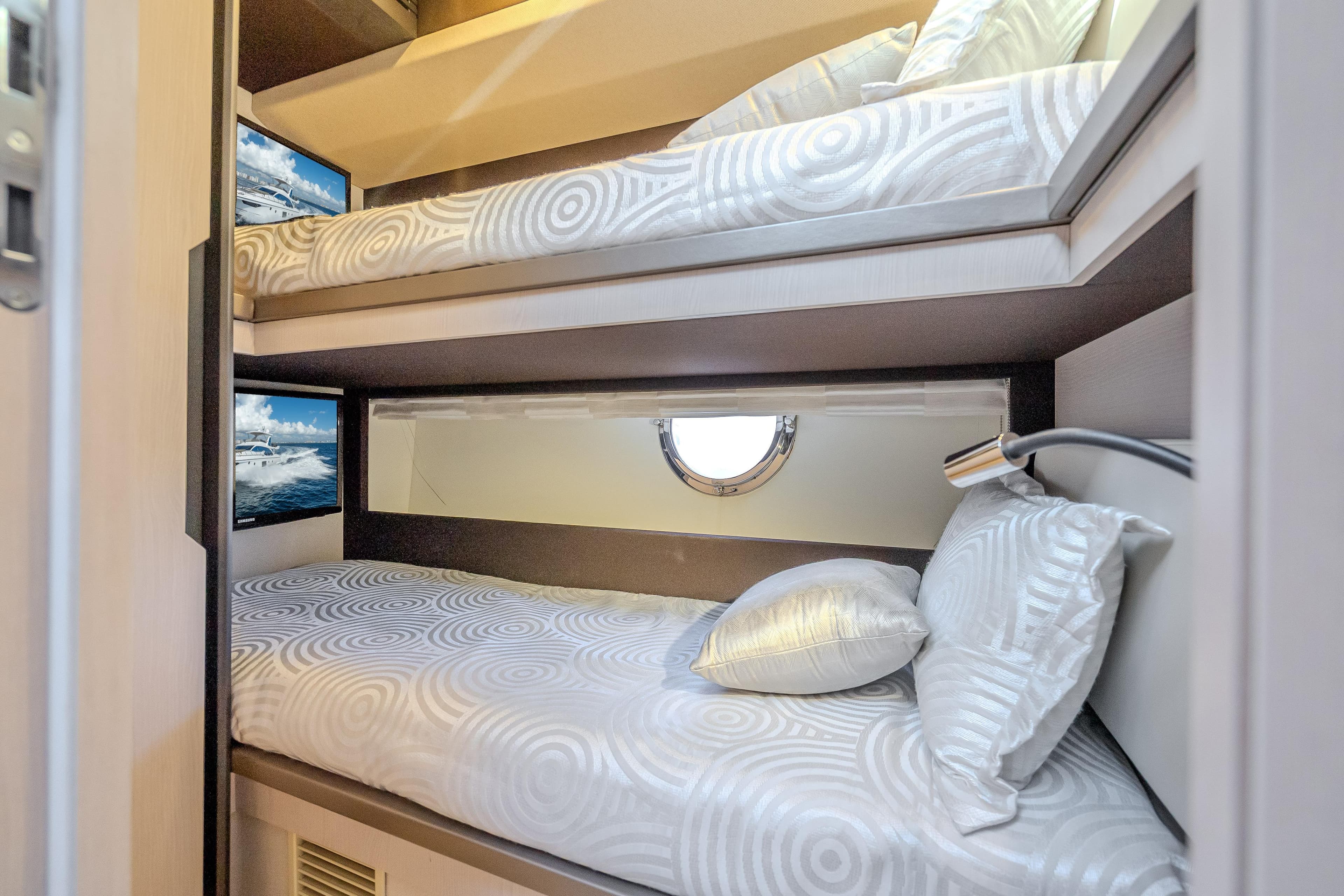 Luxurious 2019 Azimut 66 yacht cabin with stylish bunk beds and elegant decor.
