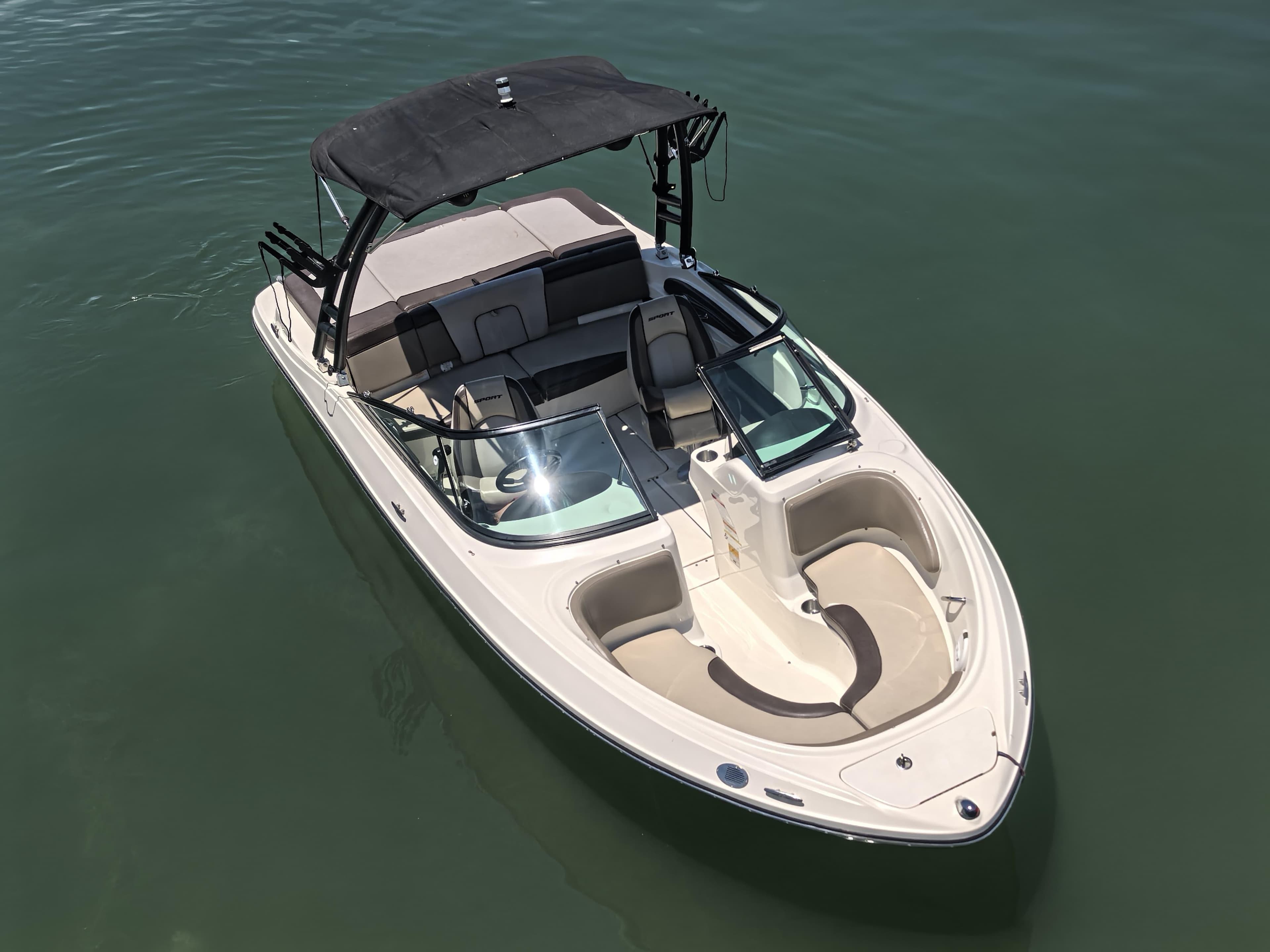 2013 Sea Ray 205 Sport boat on calm water, featuring sleek design and spacious seating.