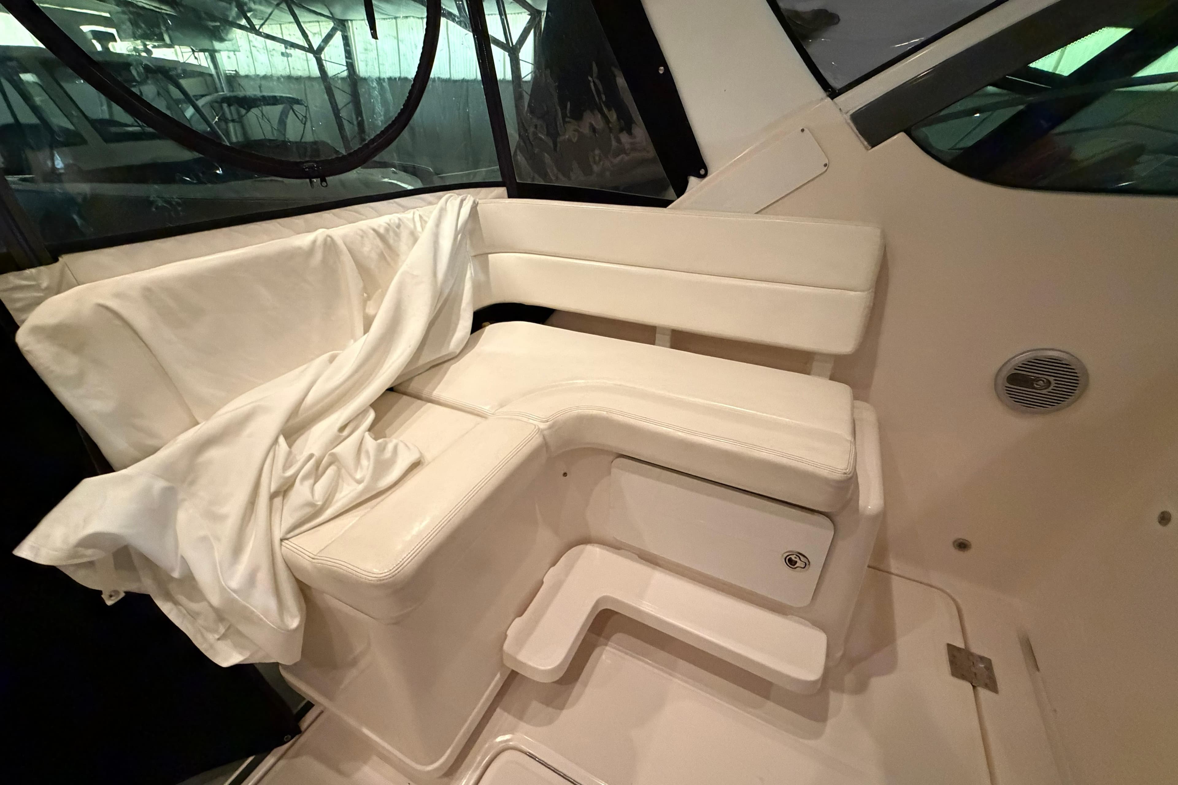 2004 Tiara Yachts 3200 Open interior seating with white upholstery and storage compartment.