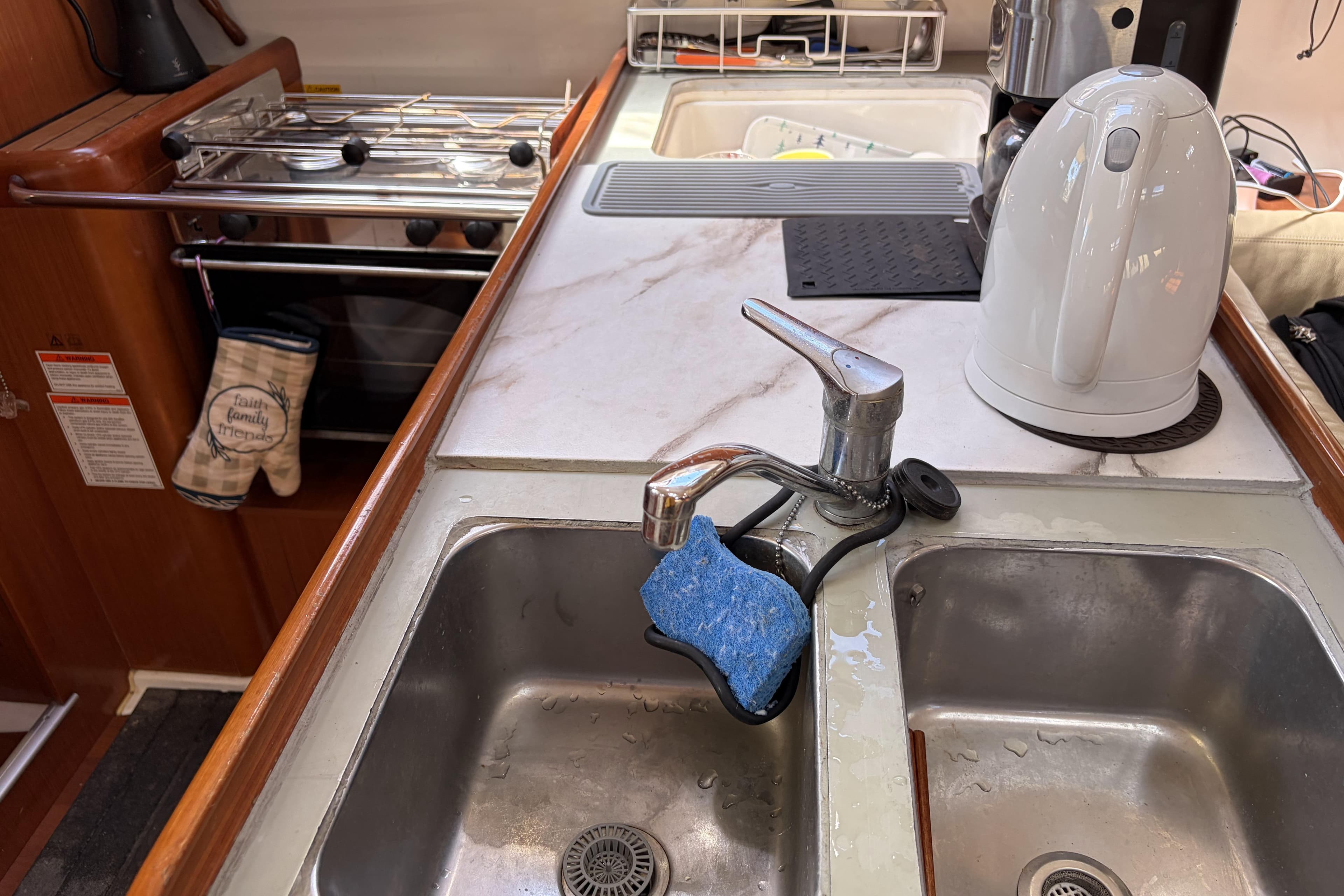 Galley kitchen in 2010 Beneteau Oceanis 37 sailboat with sink and kettle.