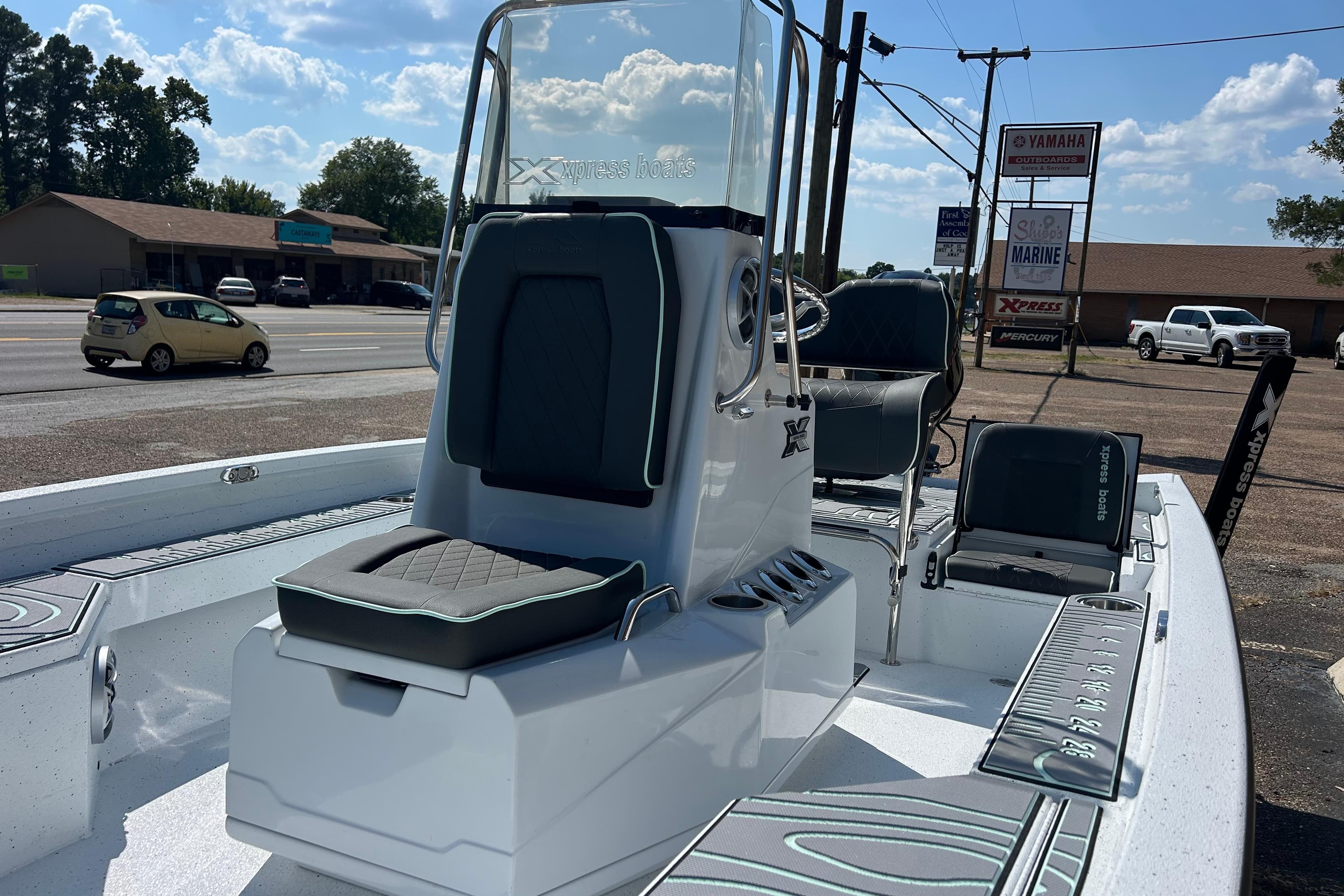 2026 Xpress H20B Bay boat with seating, parked outdoors near a road.