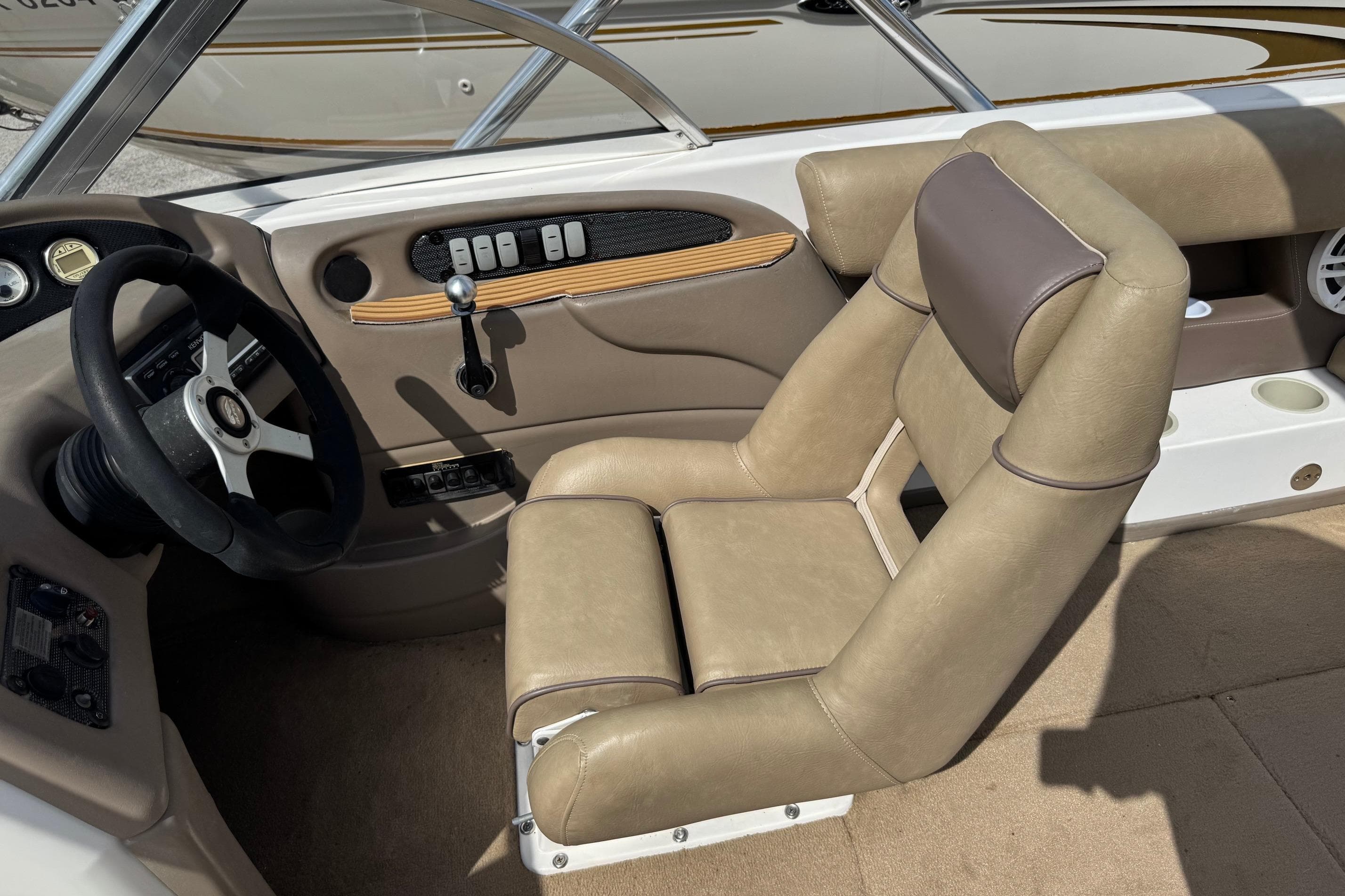 2002 Supra Launch 22 SSV boat interior with beige seating and steering wheel.