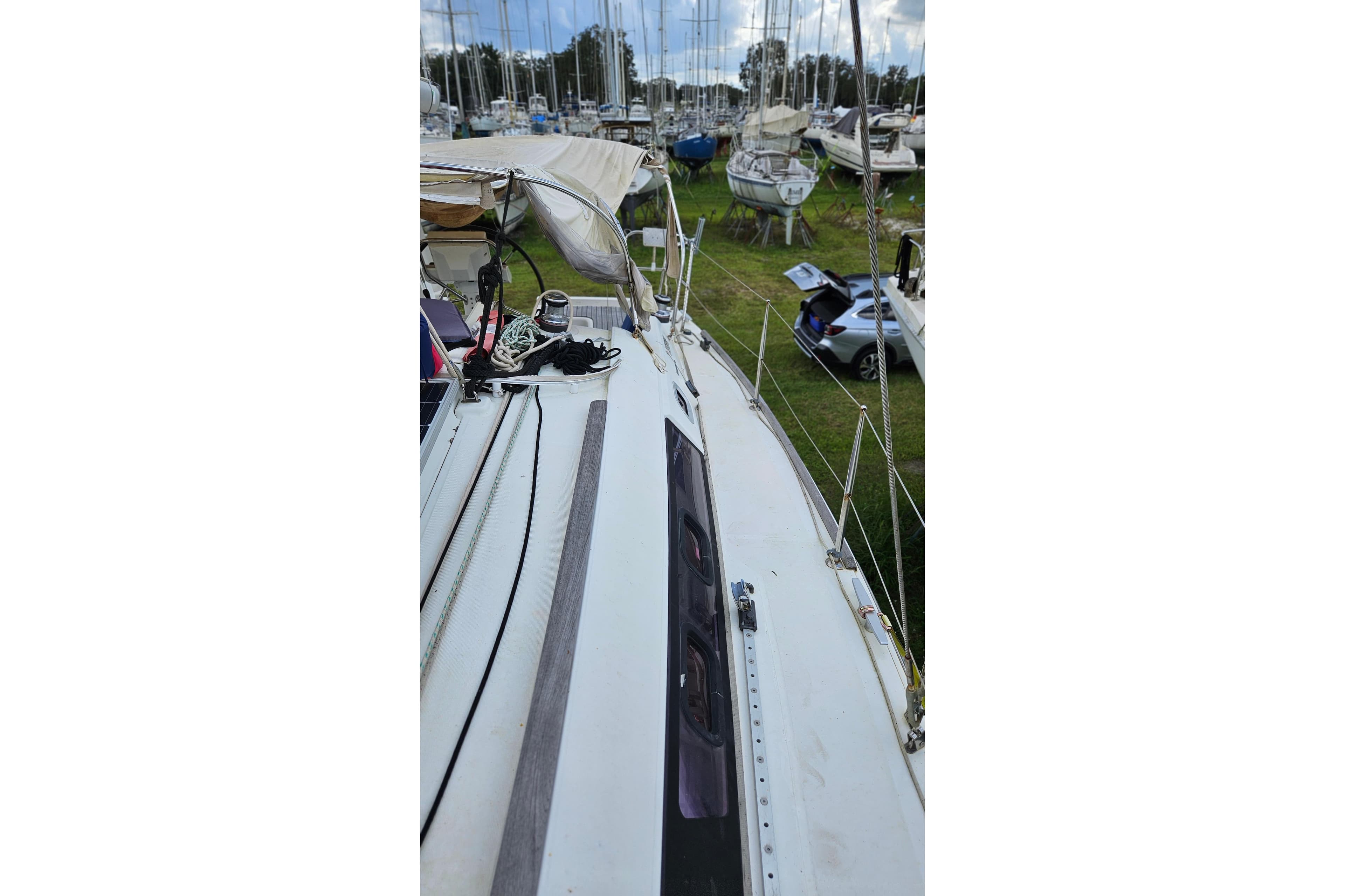 2010 Beneteau Oceanis 34 GT sailboat on land, surrounded by other boats and vehicles.