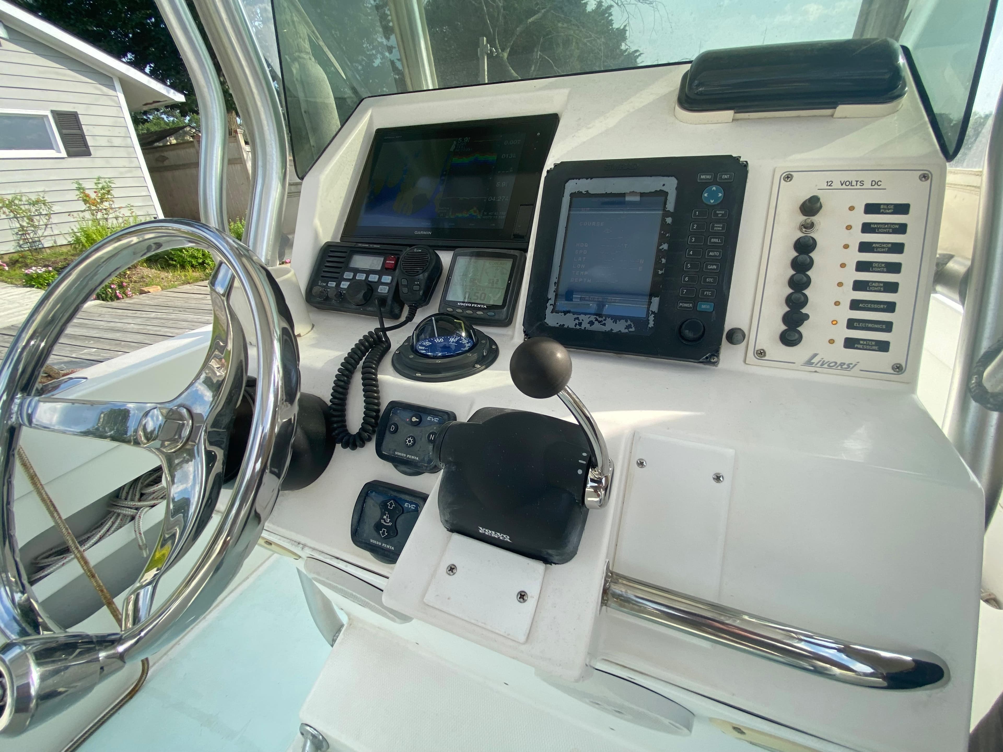Control panel of a 2006 Kryptonite 41 CC boat with steering wheel and navigation equipment.