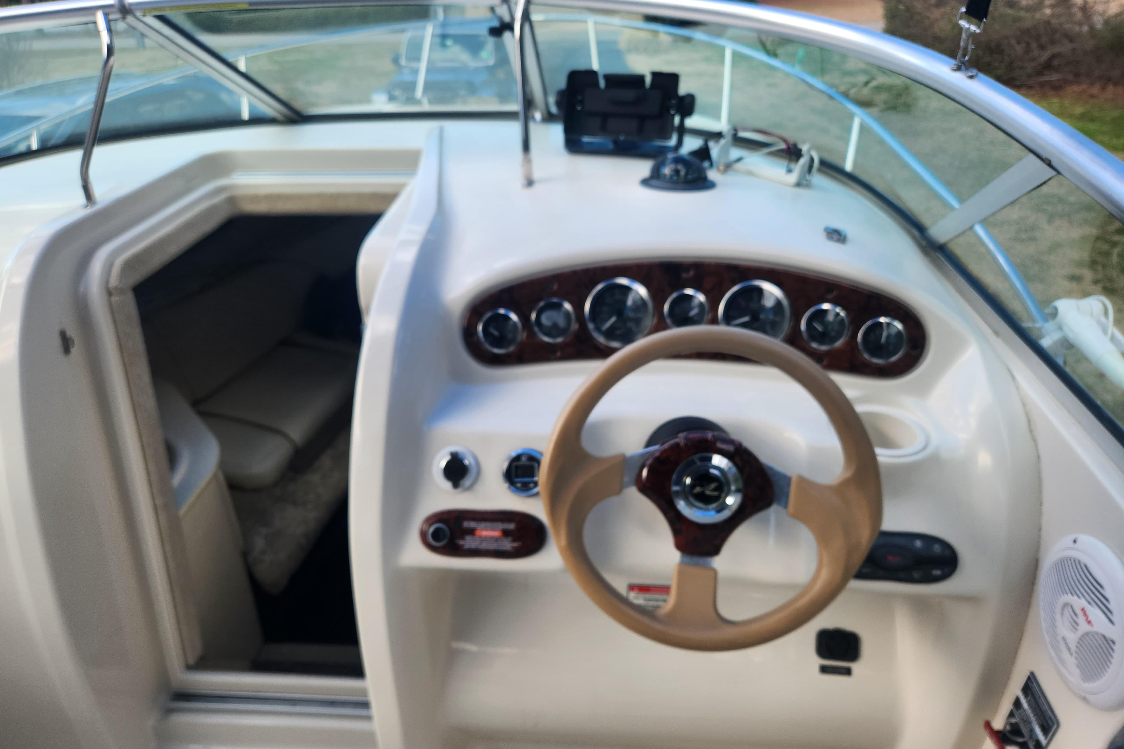 2003 Sea Ray 225 Weekender boat interior with steering wheel and cabin view.