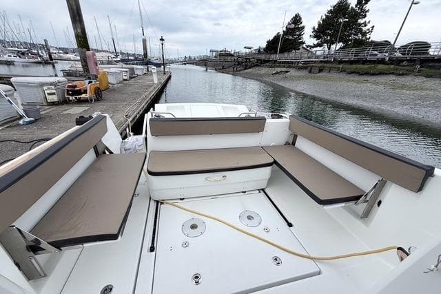 2016 Jeanneau Merry Fisher 855 Marlin boat docked, featuring spacious seating and scenic marina view.