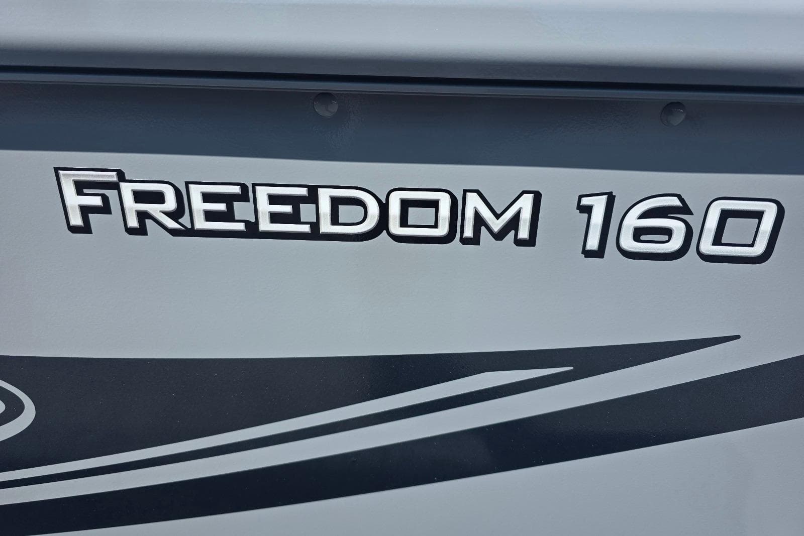 2026 Smoker Craft Freedom 160 TL boat logo on gray surface.