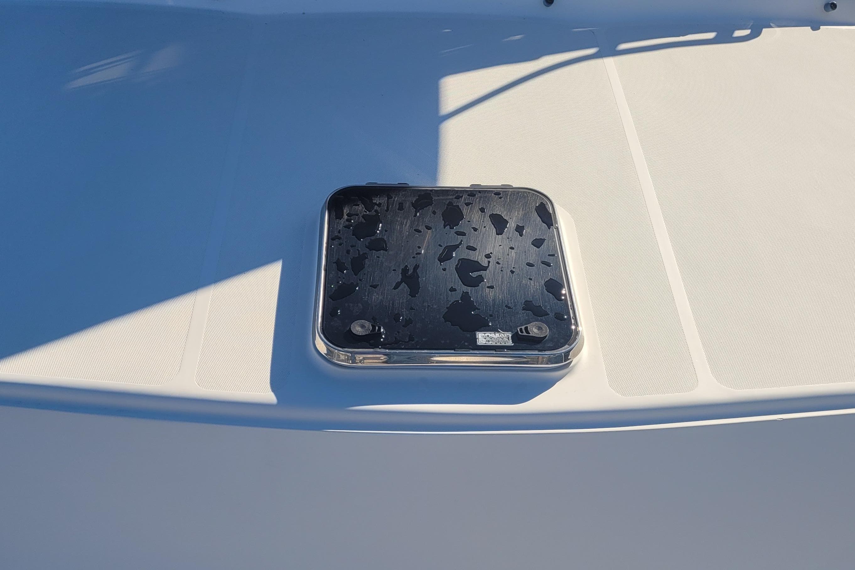Hatch on 2015 Fortier 30 boat deck with water droplets.
