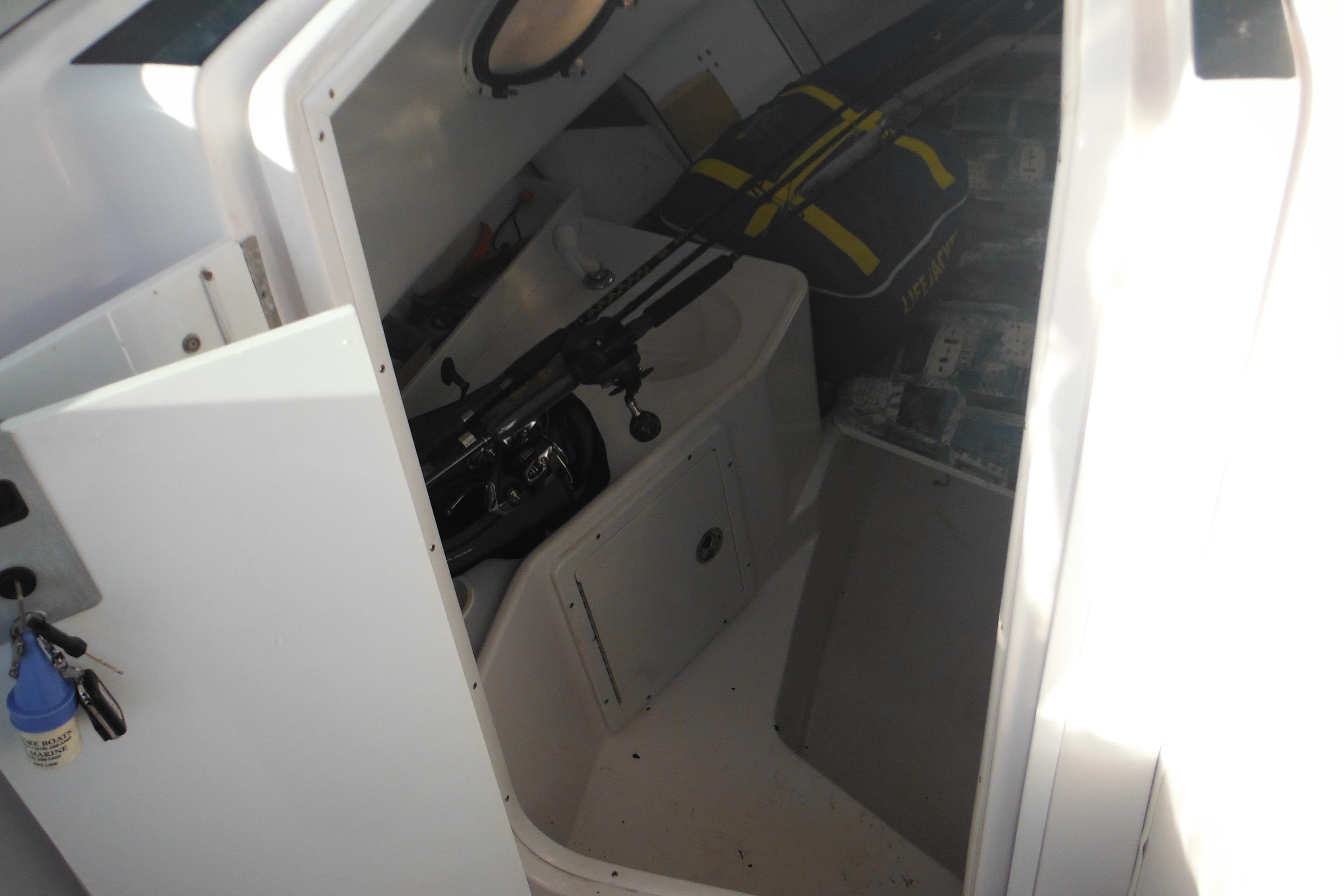 2000 Pro-Line 23 Walkaround cabin interior with fishing gear and storage.