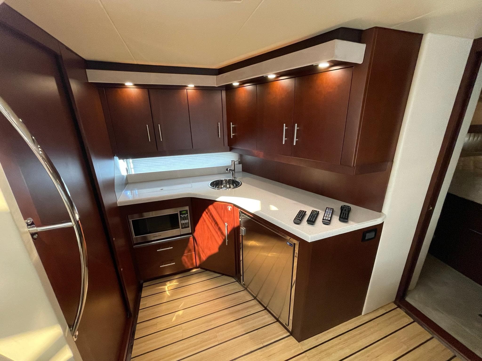 Modern kitchen in 2015 Regal 42 Sport Coupe yacht with wood cabinets and stainless appliances.