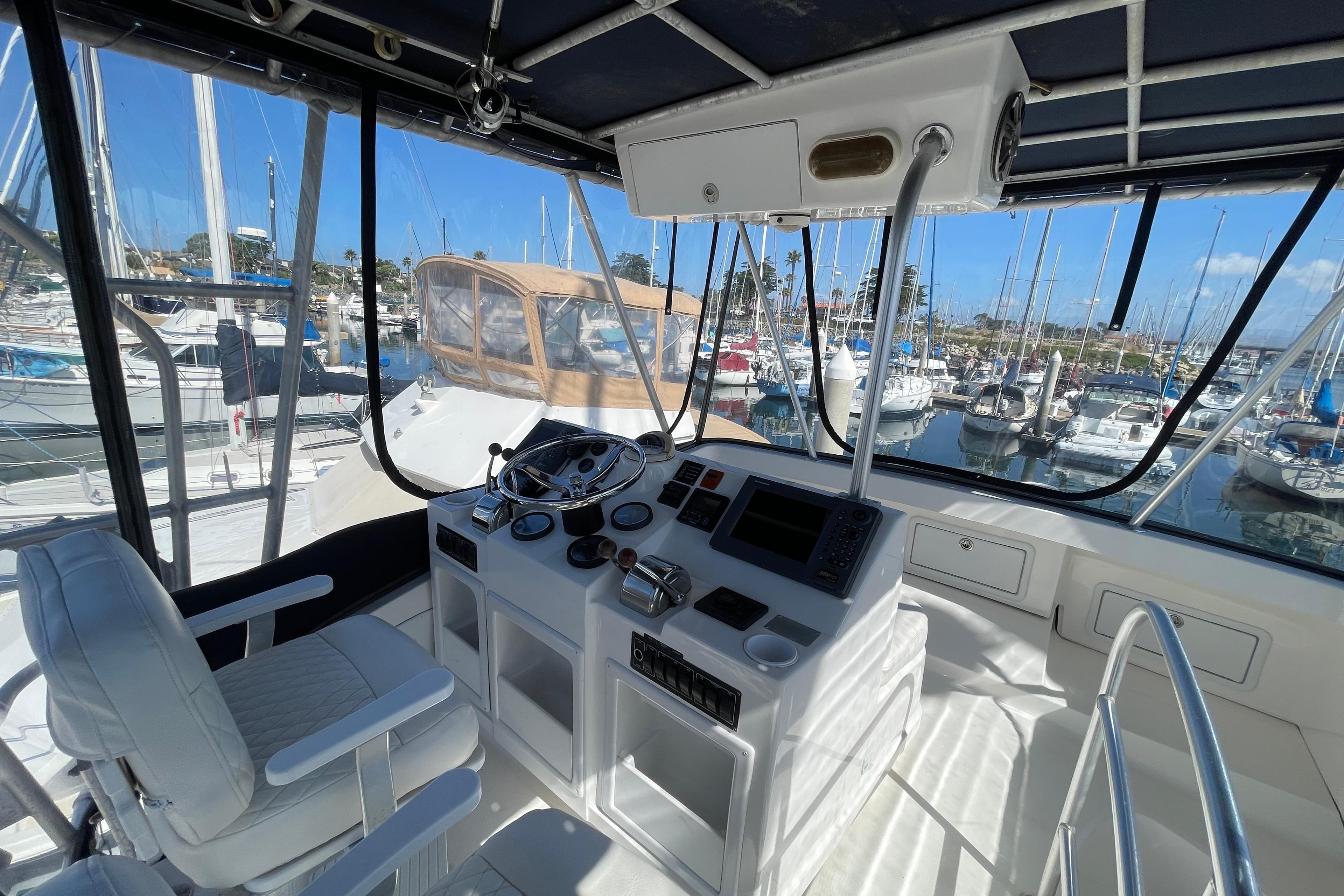 Helm of 2003 Luhrs 34 Convertible yacht with marina view.