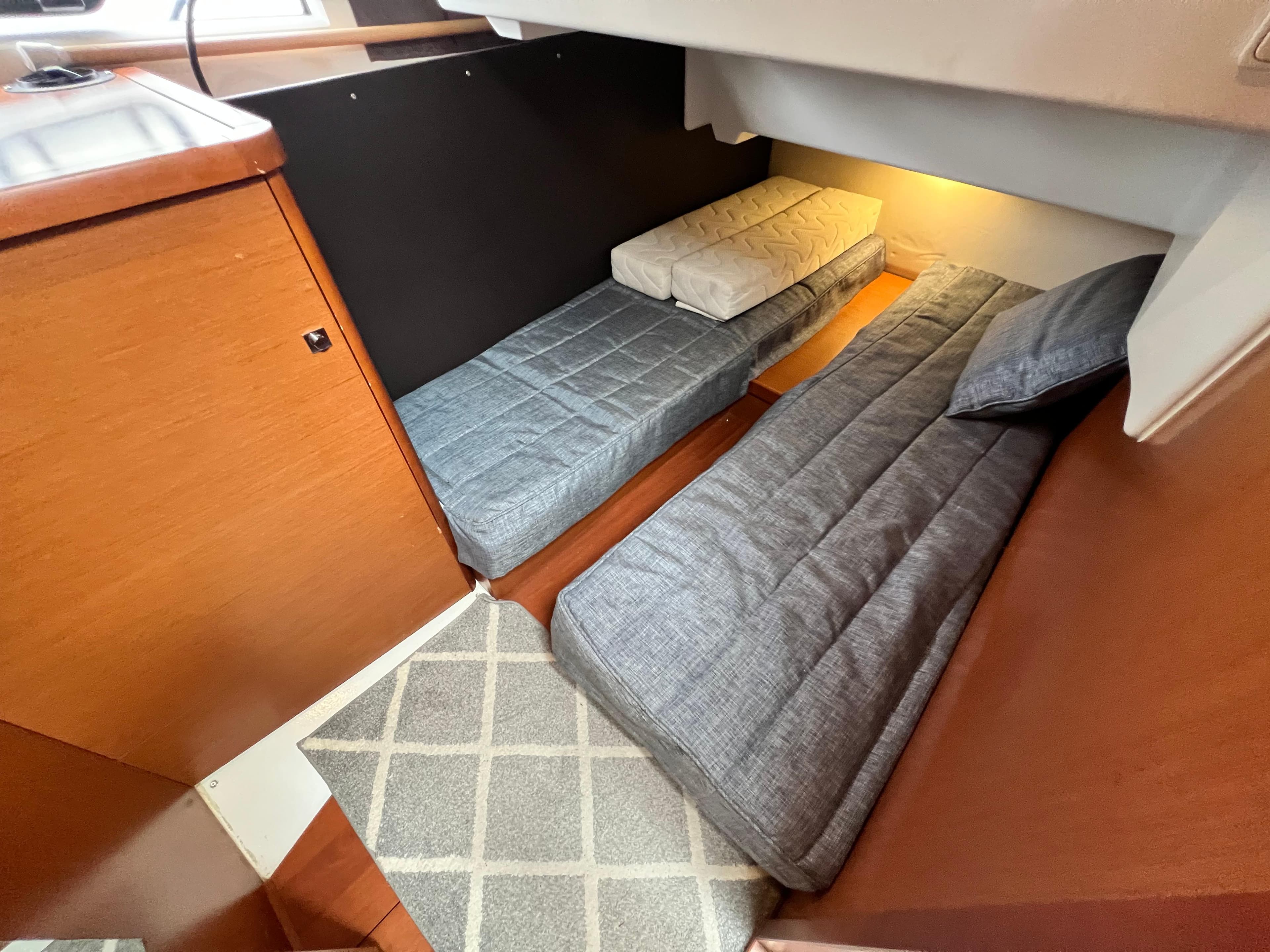 2017 Jeanneau NC11 cabin interior with twin beds and wooden finish.