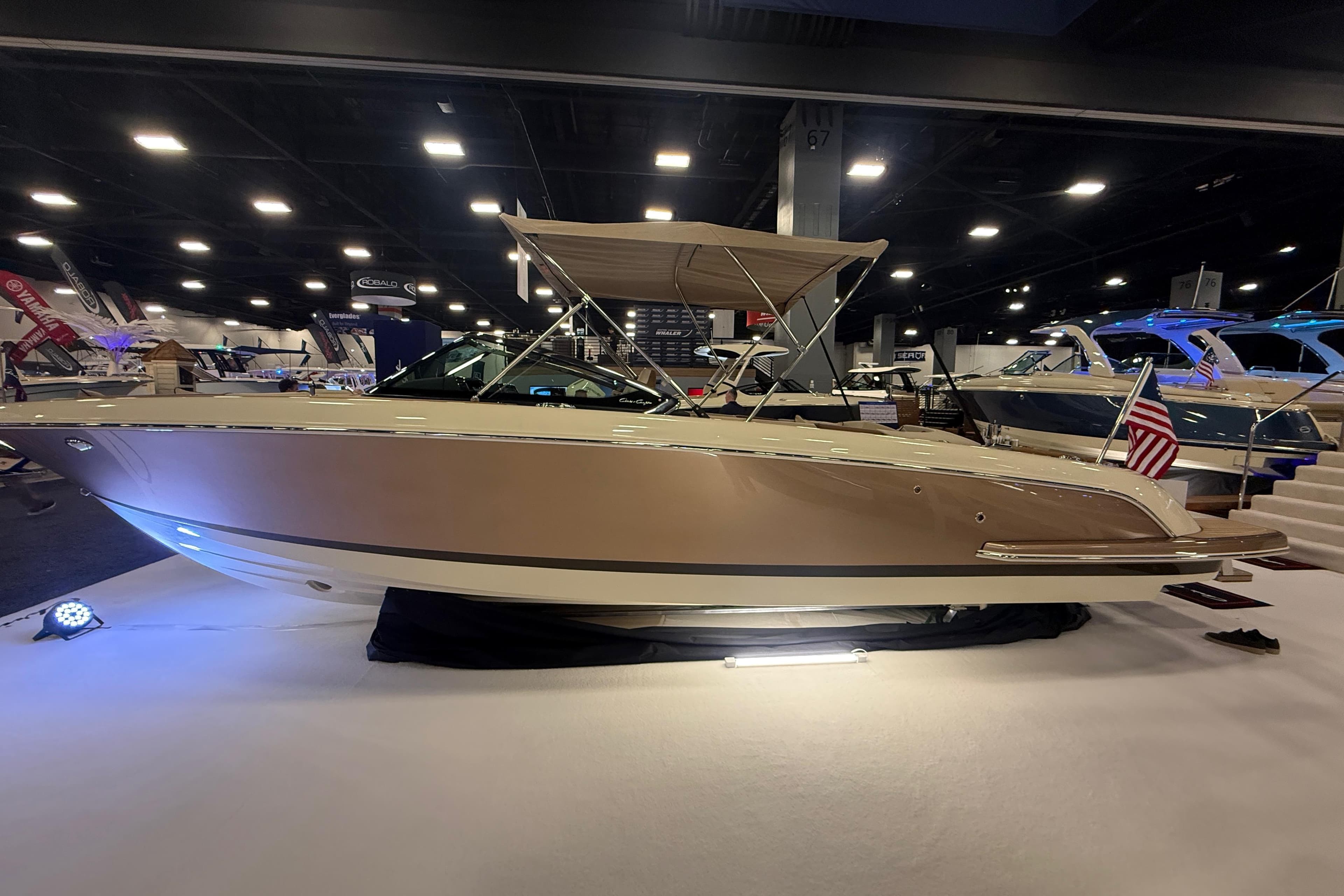 2026 Chris-Craft Launch 27 boat displayed indoors with American flag.