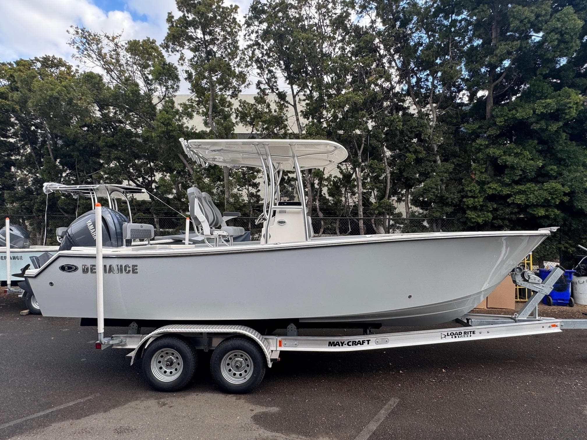 2025 Defiance Catalina 240 boat on trailer, parked outdoors, surrounded by trees.