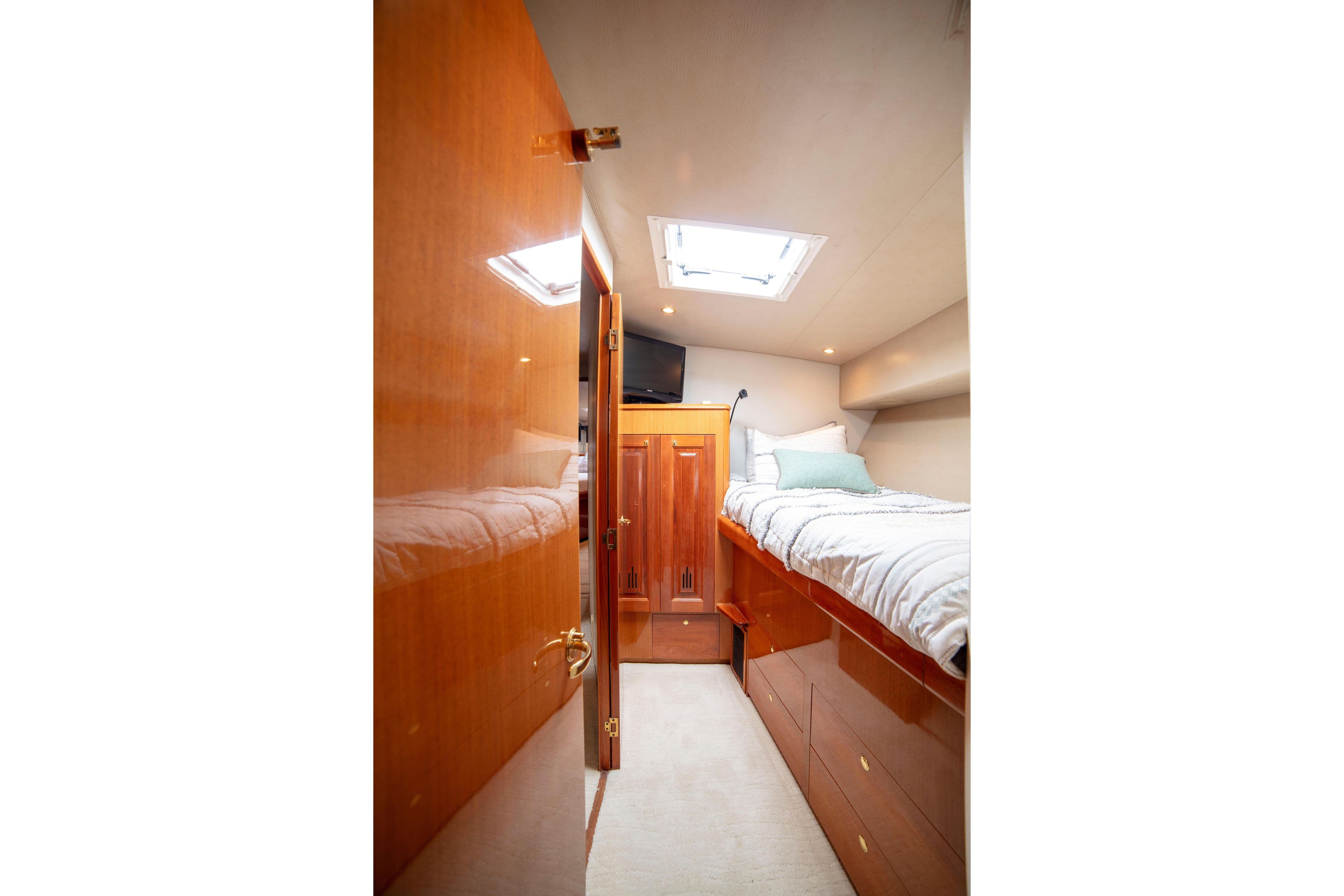 Cozy cabin interior of 2002 Viking 65 Enclosed Bridge yacht with wooden finishes.