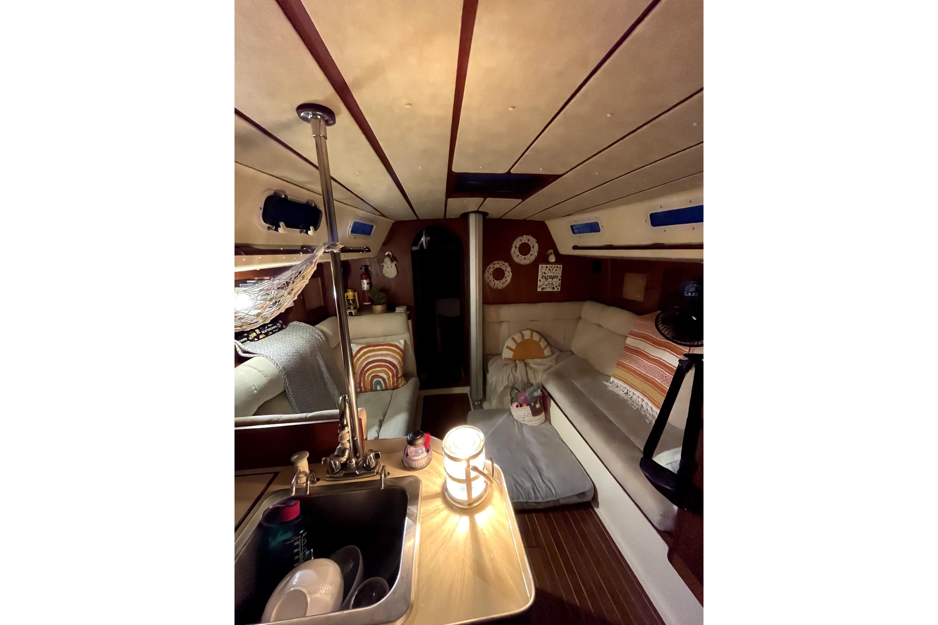 Cozy interior of 1981 Canadian Sailcraft 36 sailboat with comfortable seating and warm lighting.