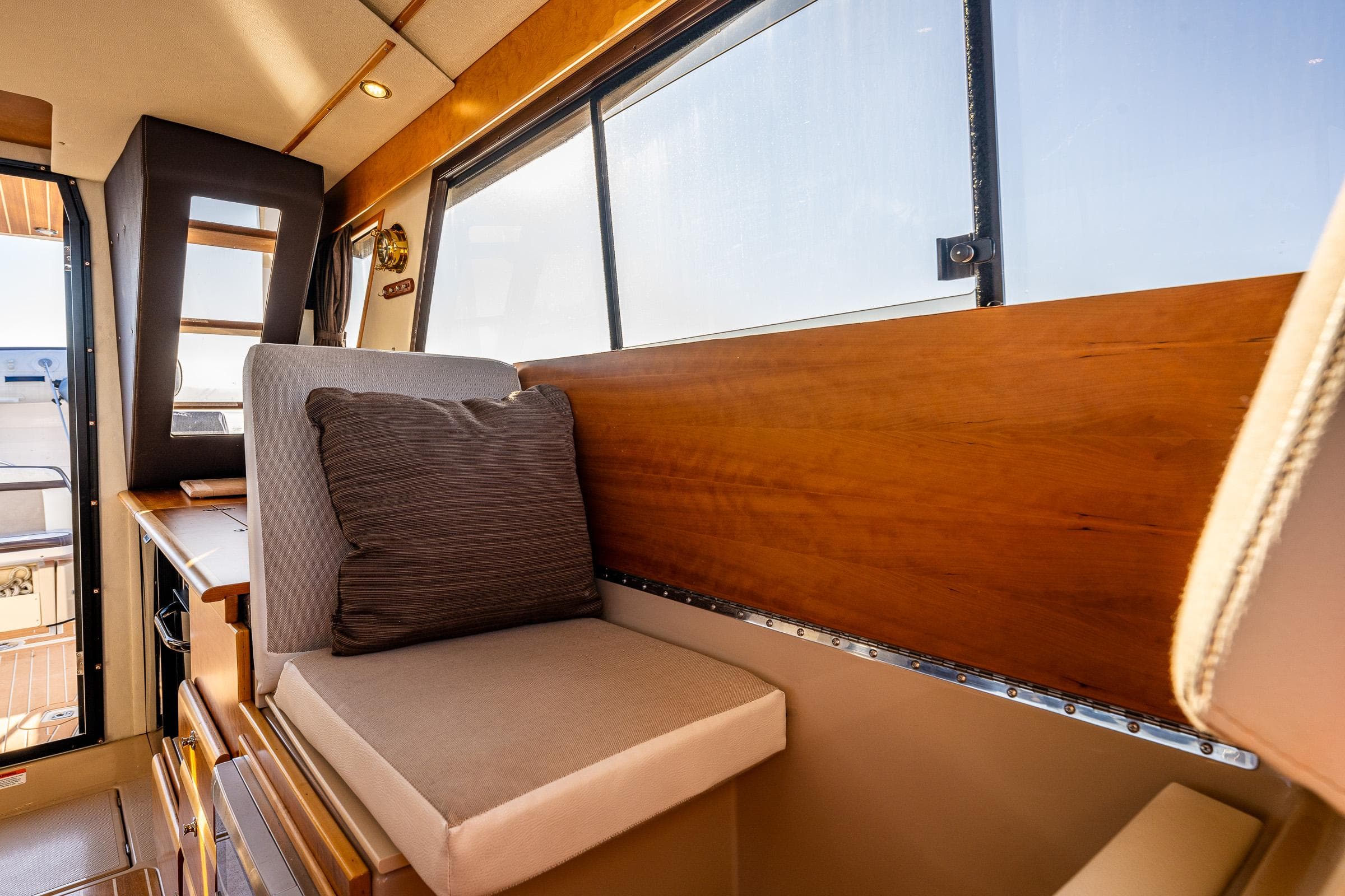 Interior of 2016 Cutwater 30 Command Bridge, featuring cushioned seating and wooden accents.